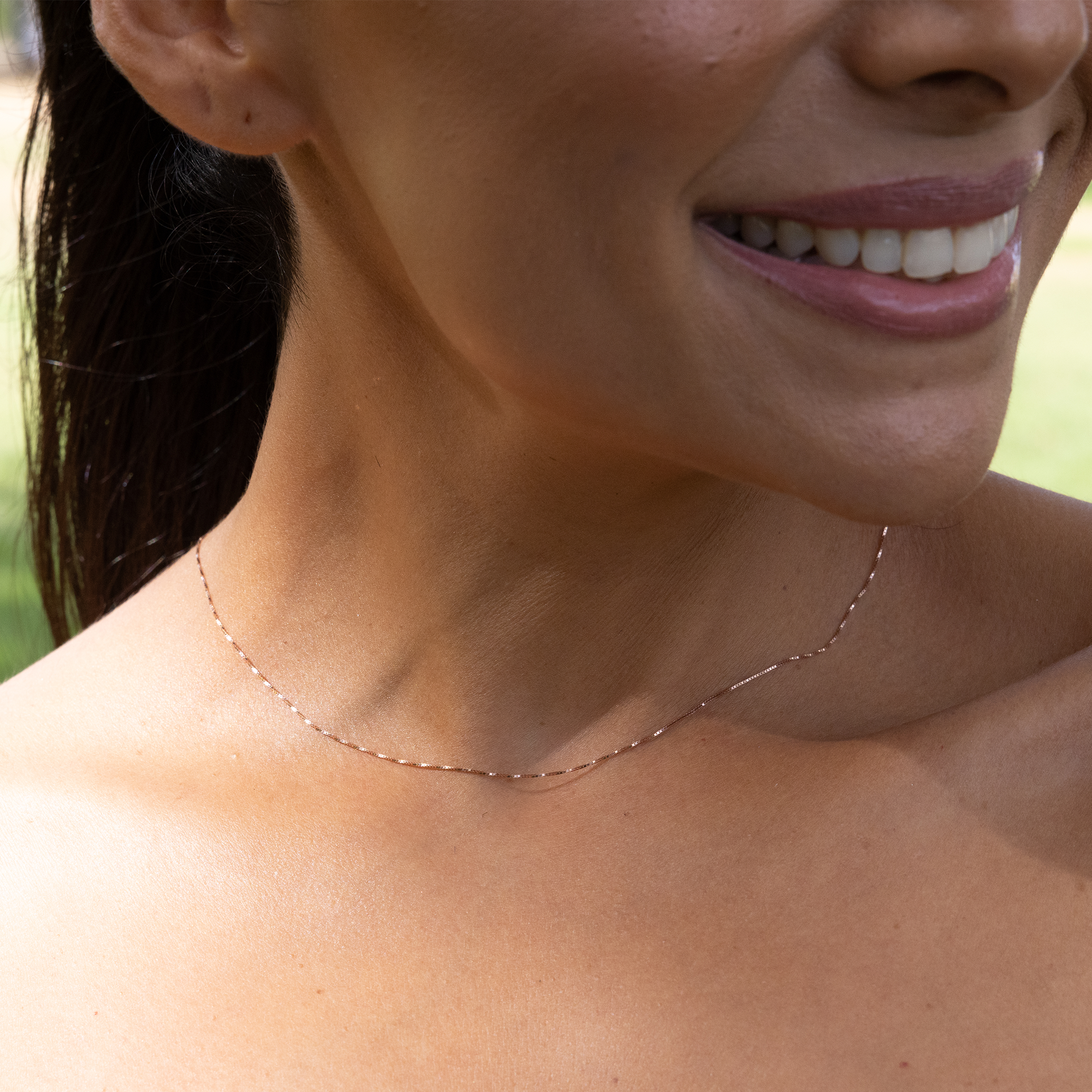 0.6mm Lite Box Chain in 14k Rose Gold on a womanʻs neckline