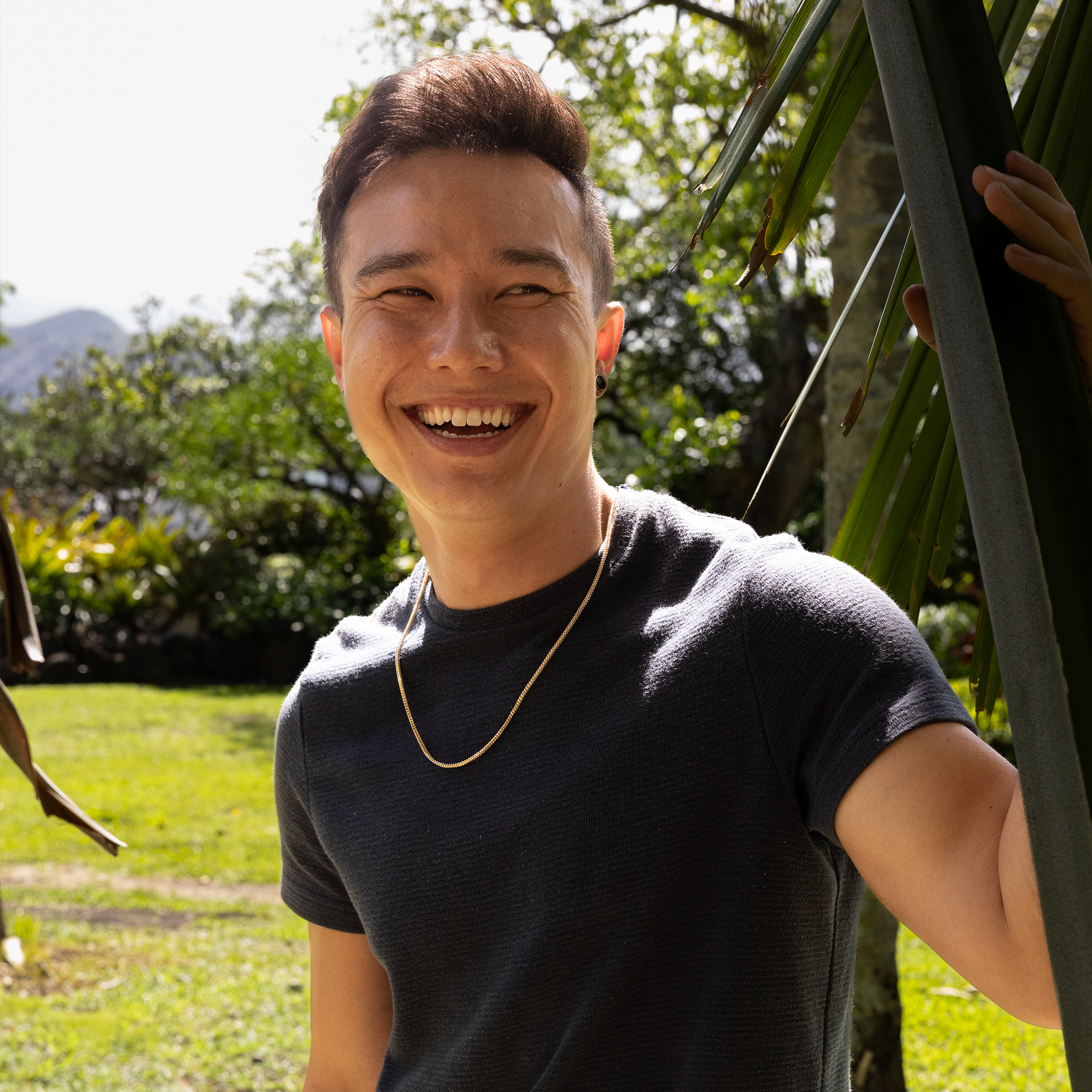 Man smiling outdoors wearing 2.5mm Hollow Franco Chain in 14k Yellow Gold