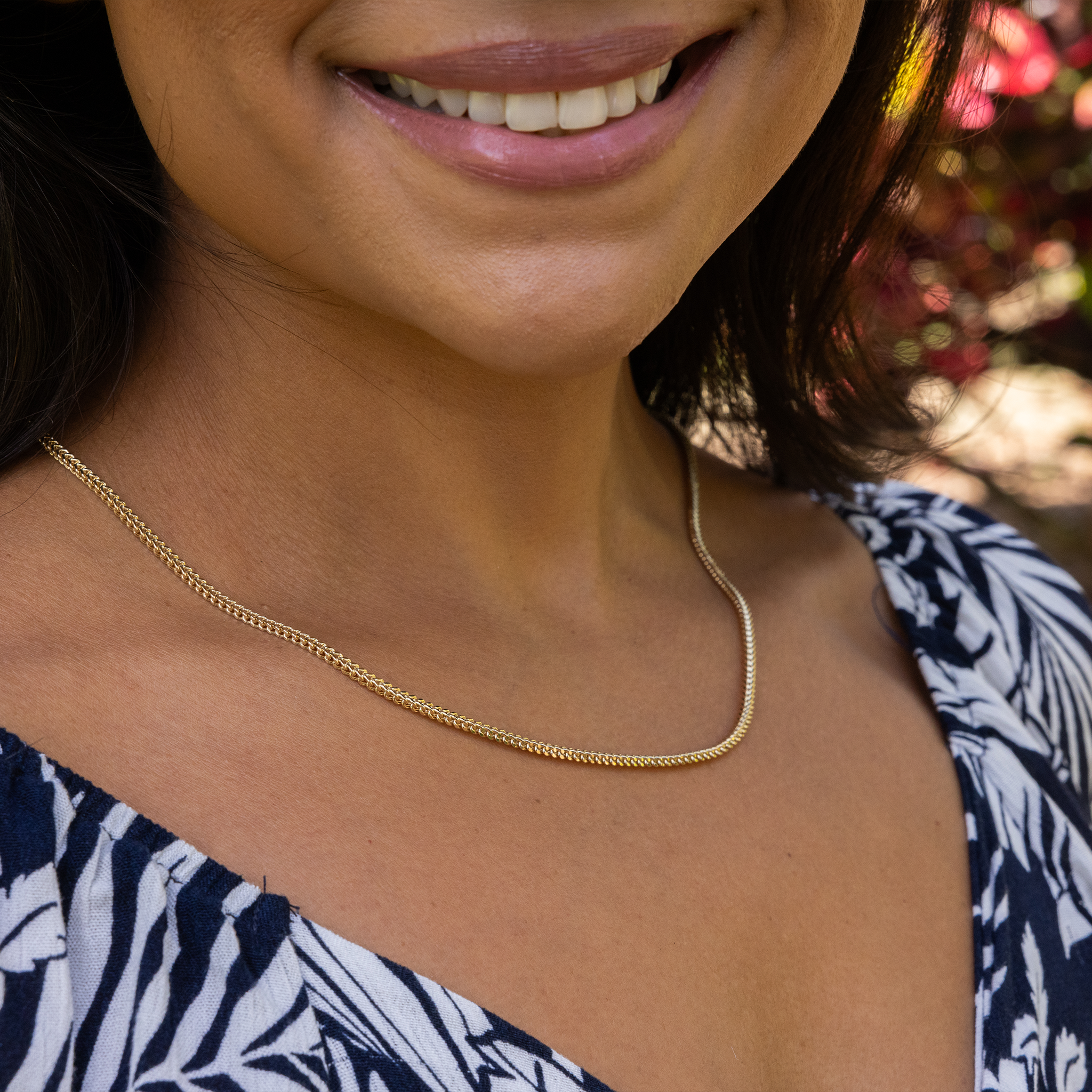 Close up of 2.5mm Hollow Franco Chain in 14k Yellow Gold on a womanʻs chest
