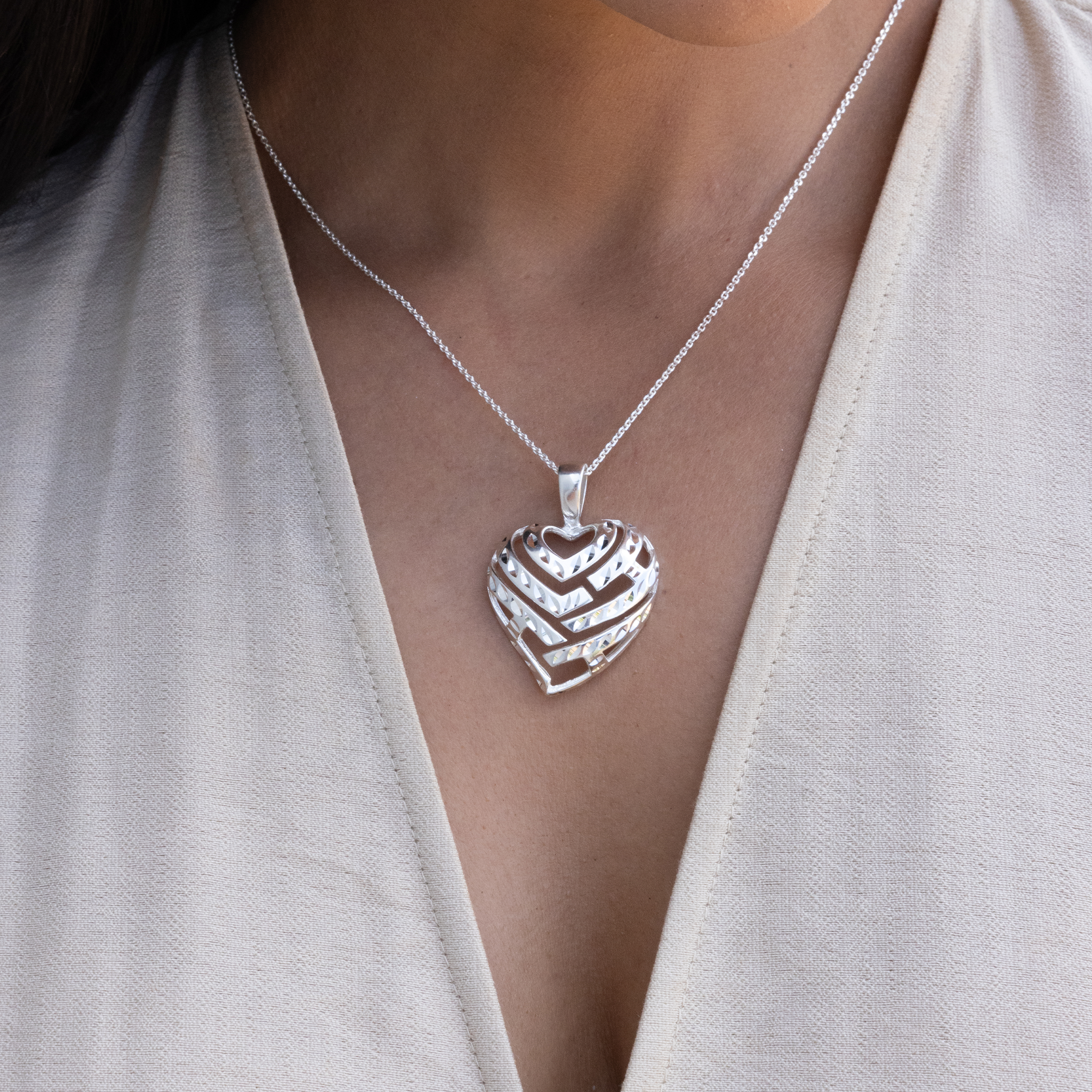 Close up of womanʻs chest with Aloha Heart Pendant Necklace in Sterling Silver on a Chain