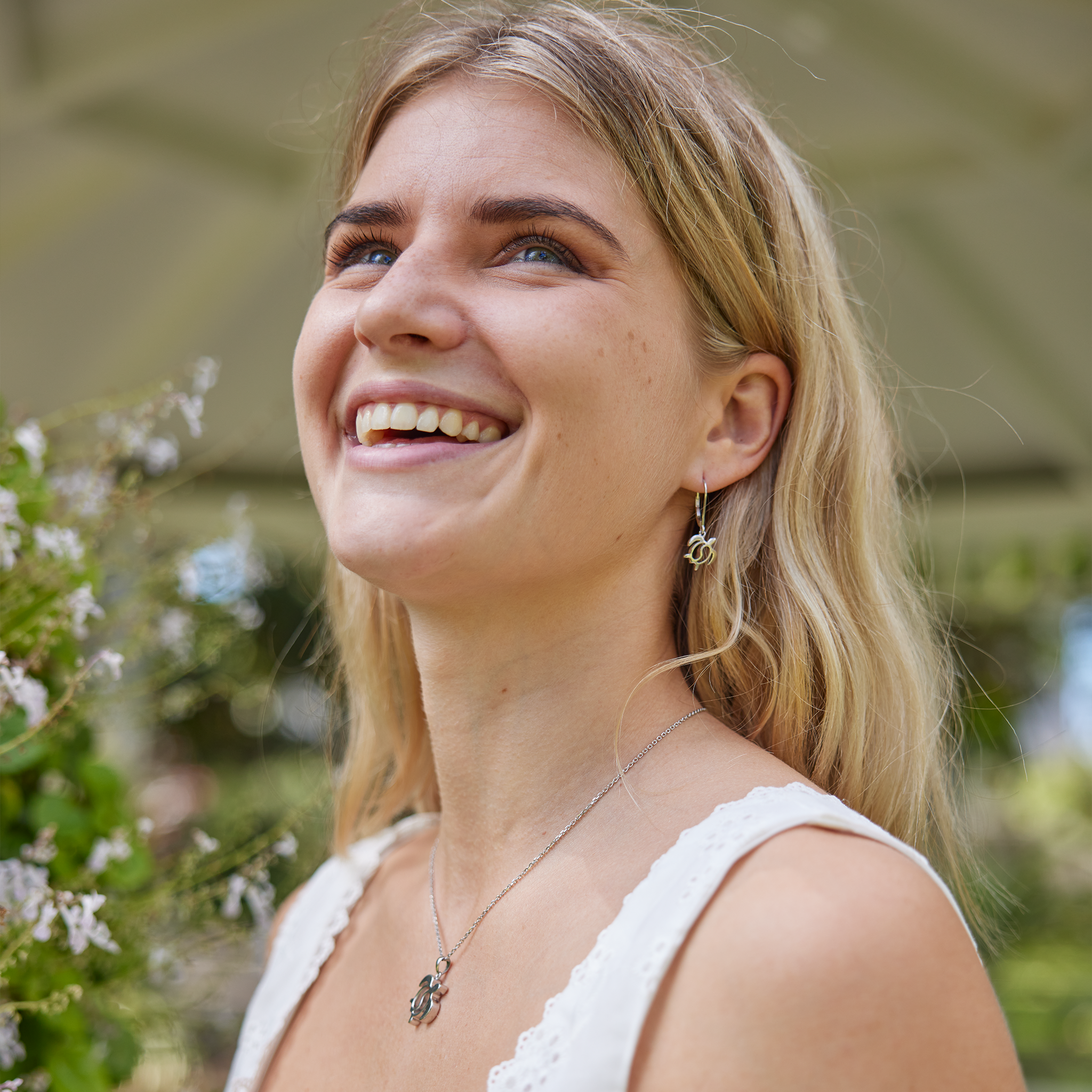 laughing woman in garden wearing honu yin yang set in sterling silver
