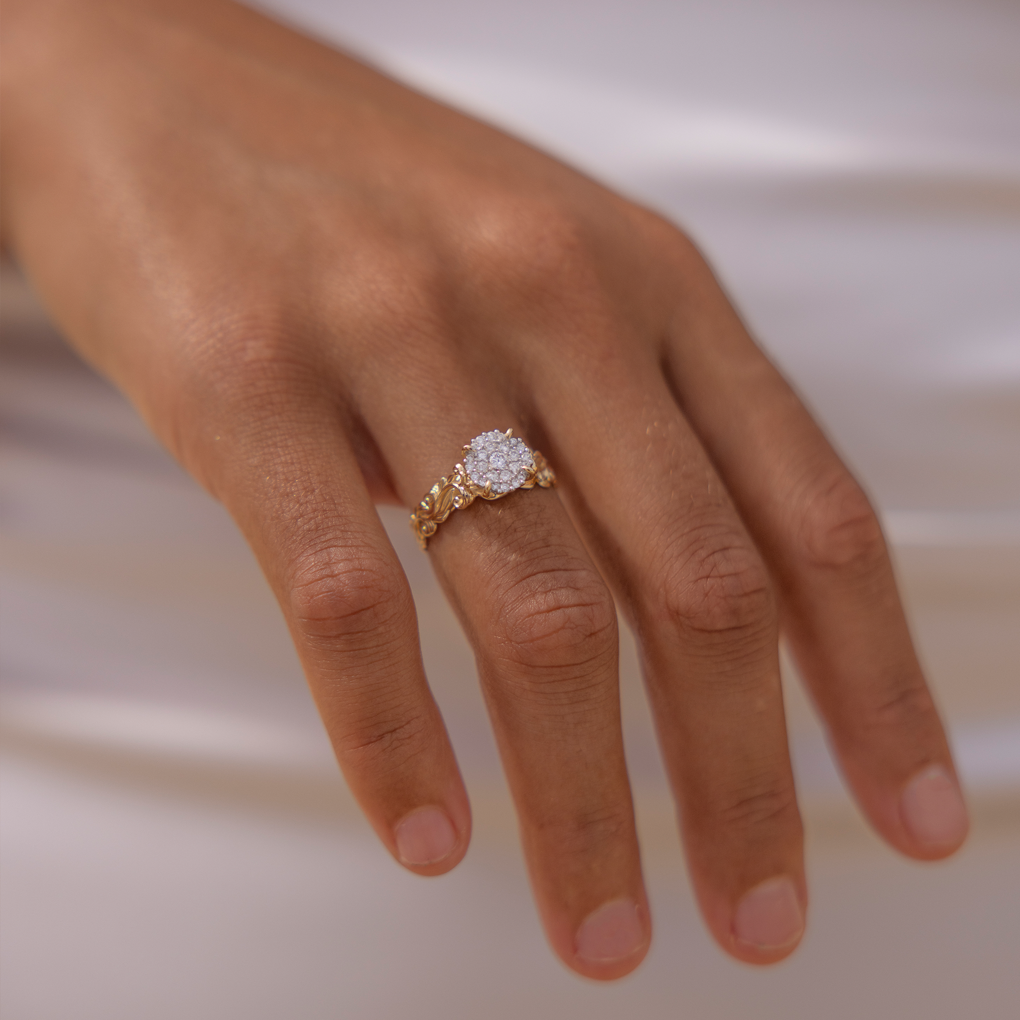 Close up of Living Heirloom Engagement Ring in Gold with Diamonds on a woman's hand against a white dress
