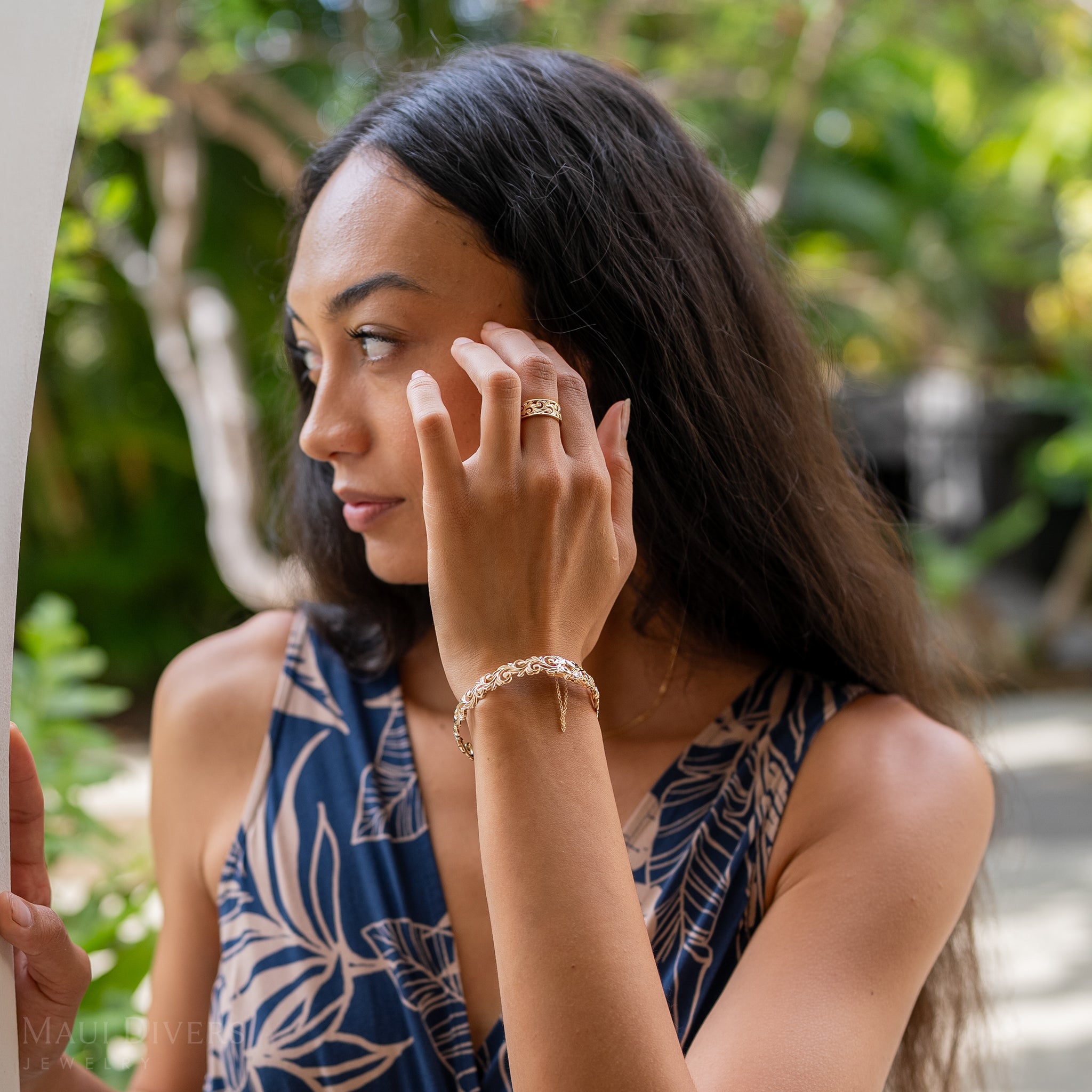 Woman in a garden wearing a Living Heirloom Hinge Bracelet in 14k Yellow Gold