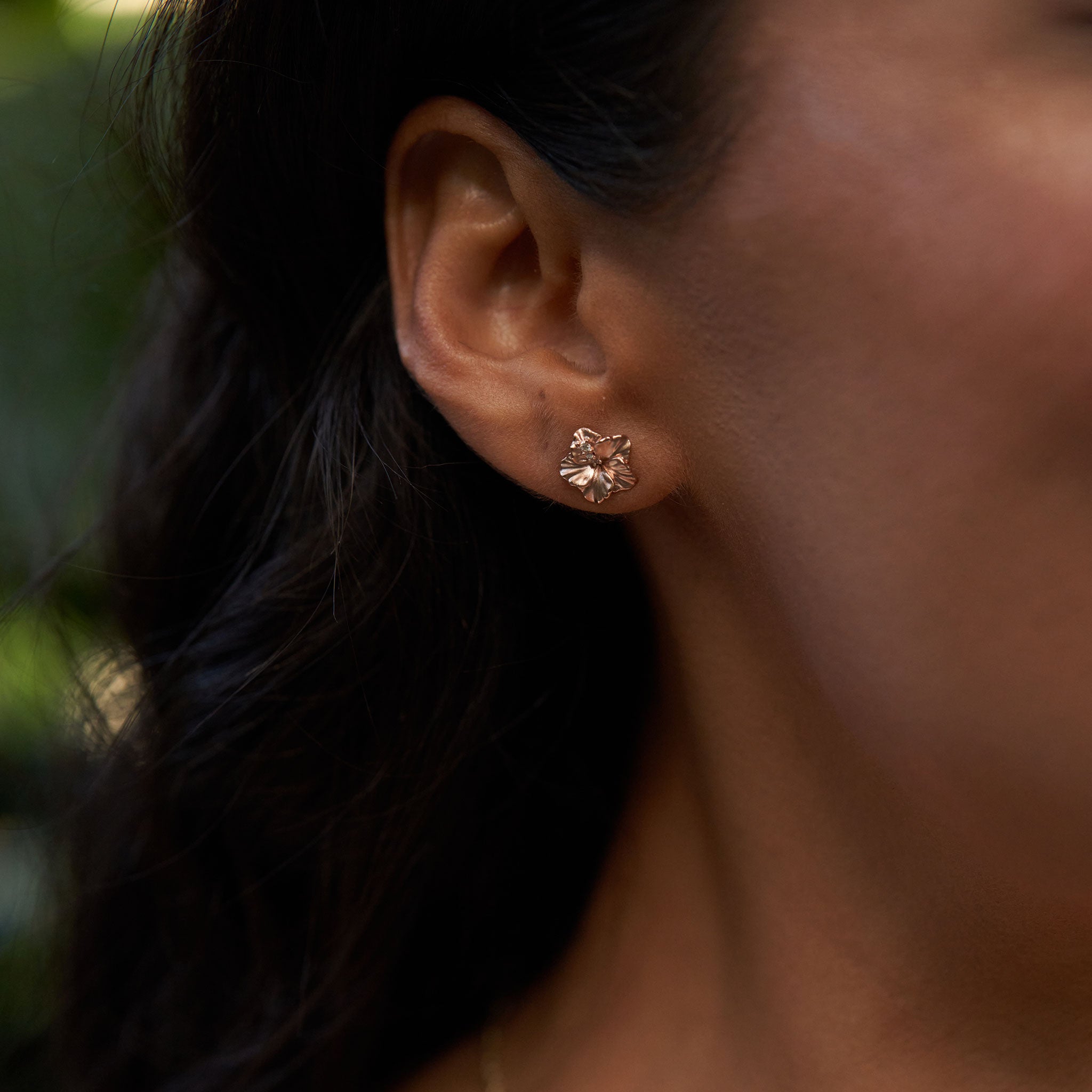 Close up of 9.5mm Diamond Hibiscus Earrings in 14k Rose Gold on ear