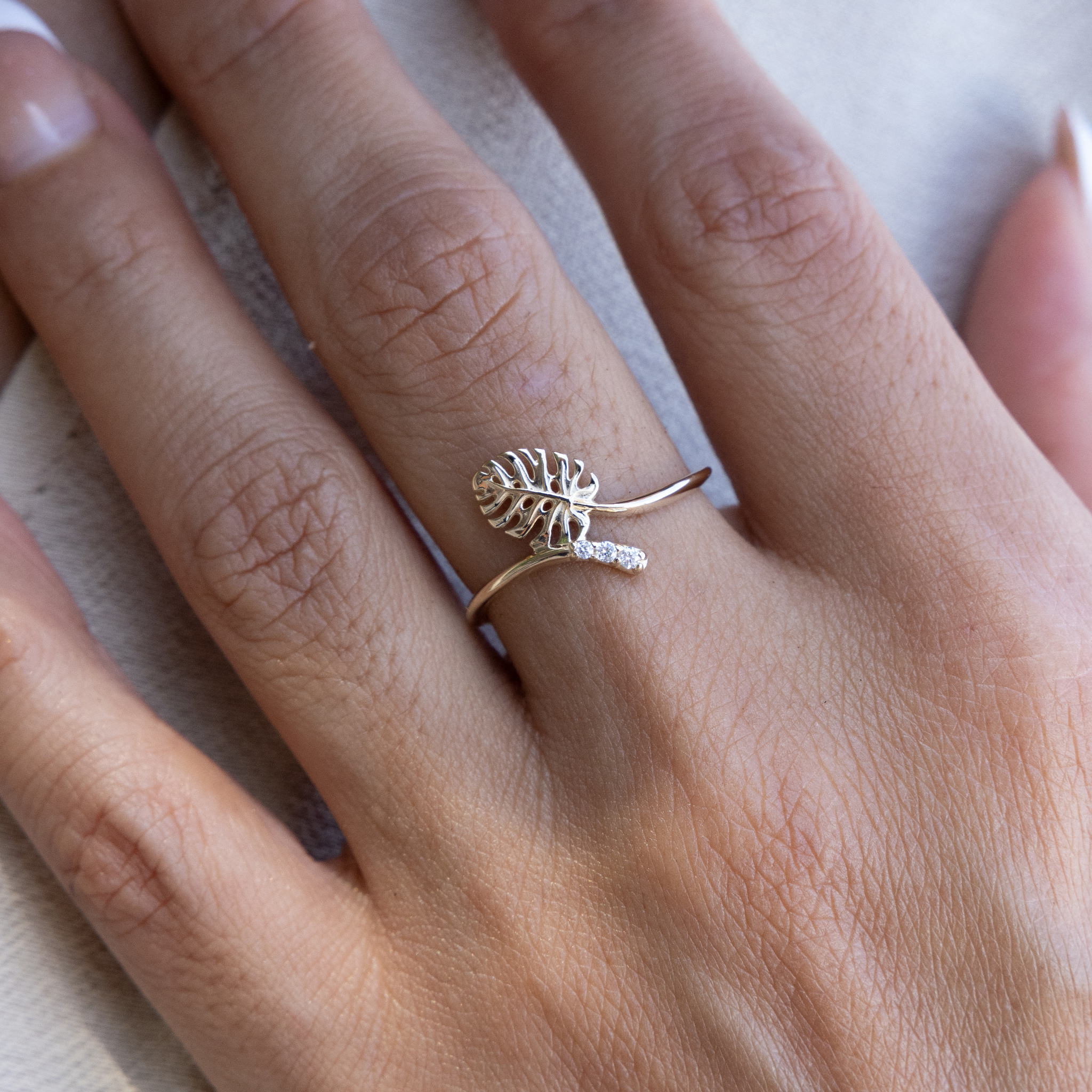 Close up of a 9mm Monstera Ring in Gold with Diamonds on a hand