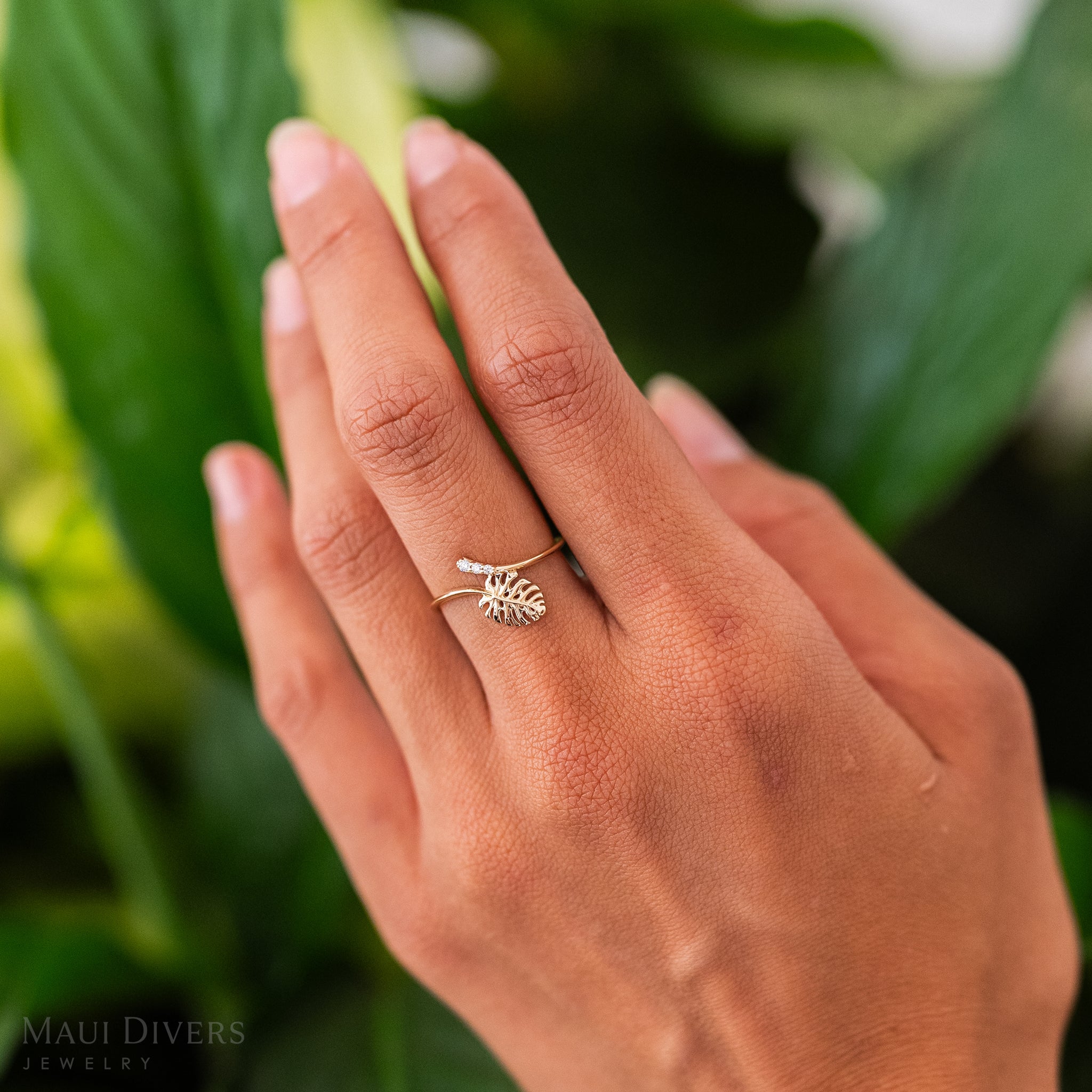 9mm Monstera Ring in Gold with Diamonds on a hand with leafy greens in the background