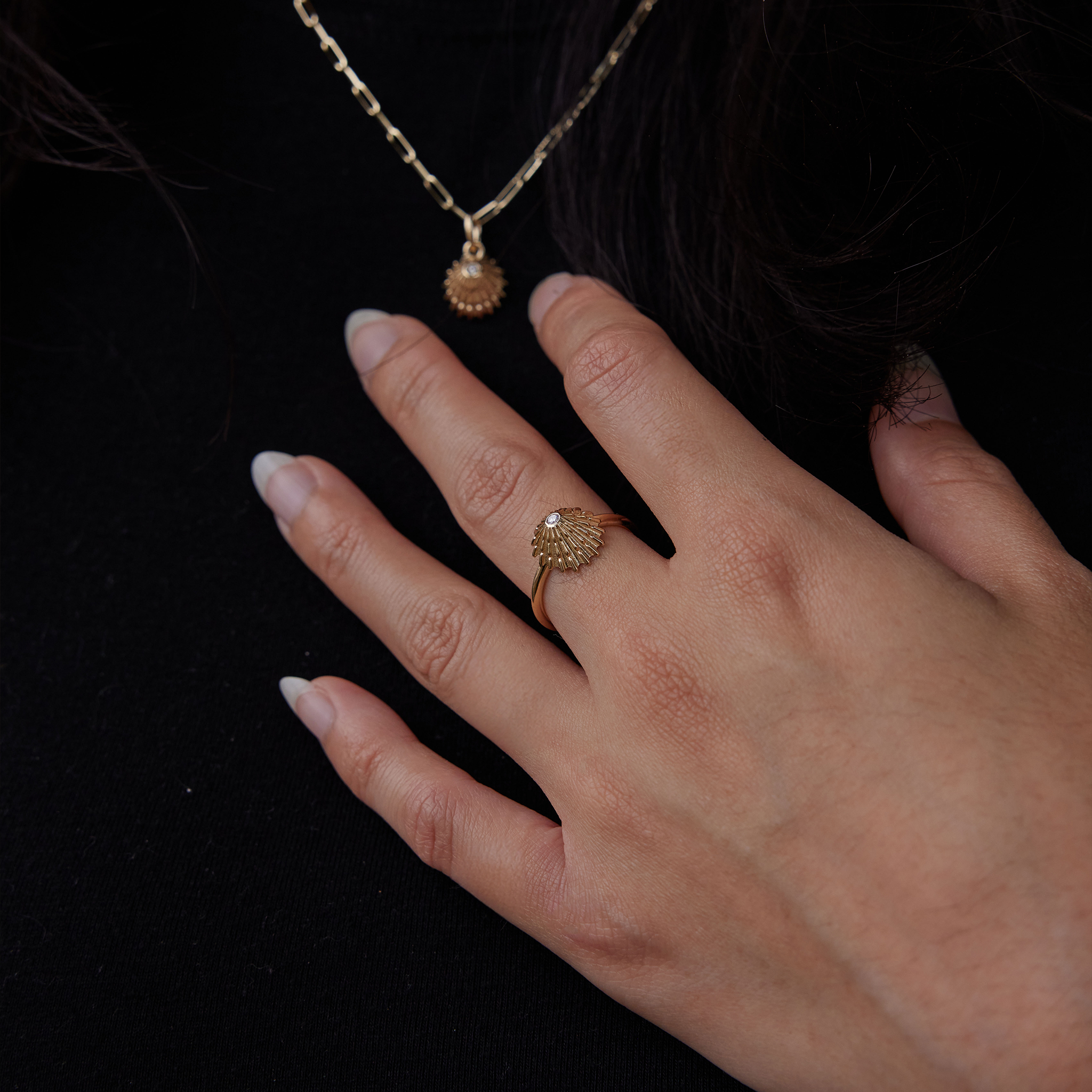 Close up of person wearing 12mm ʻOpihi Ring and Pendant in Gold with Diamonds