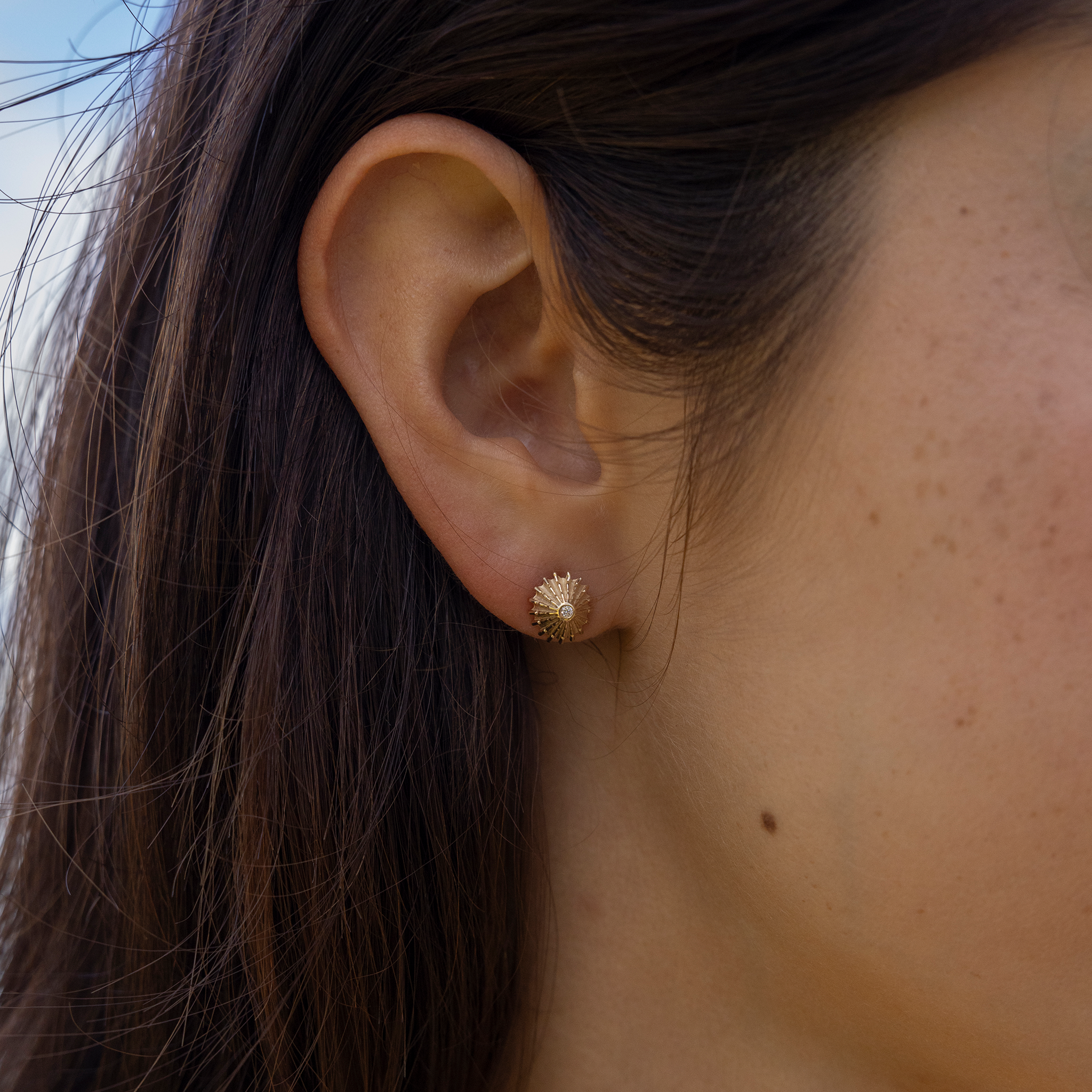 Close up of 10mm ʻOpihi Earrings in Gold with Diamonds on ear