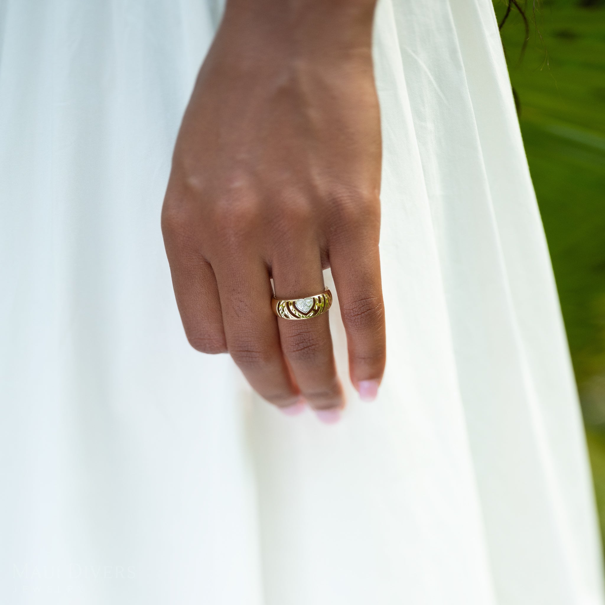 8mm Aloha Heart Ring in Gold with Diamonds on a hand against a white dress