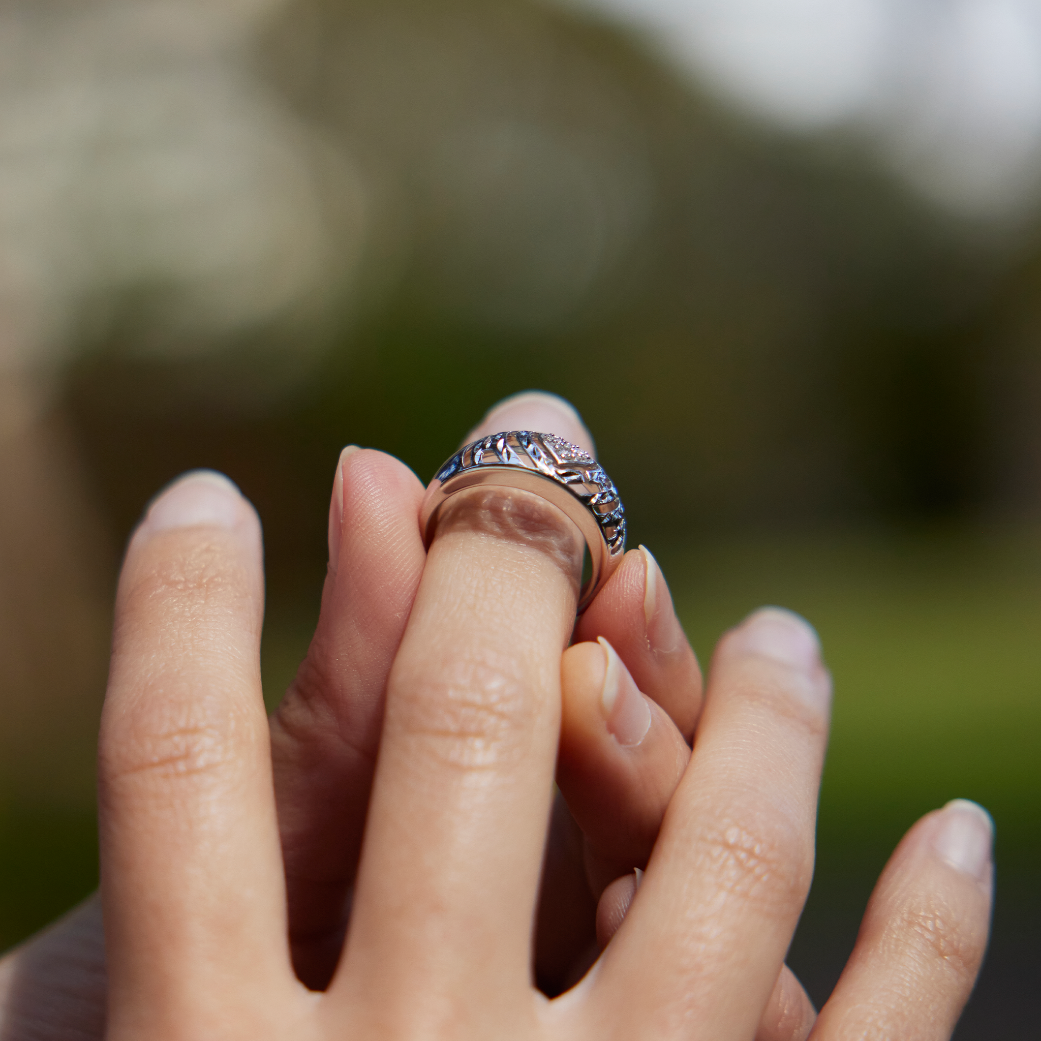 Close up of 8mm Aloha Heart Ring in White Gold with Diamonds being placed on a finger