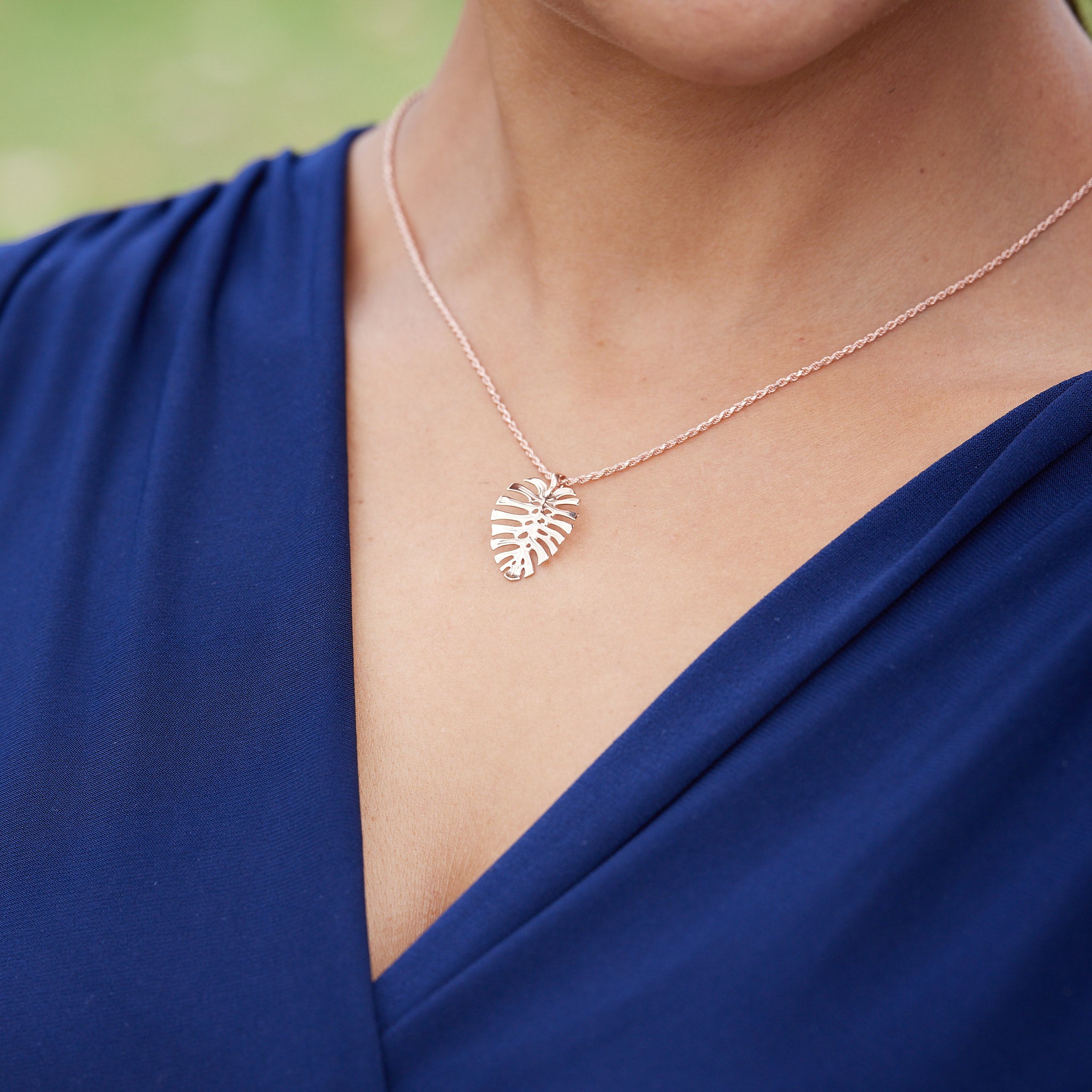 A woman wearing a Monstera Pendant in Rose Gold - 20mm - Maui Divers Jewelry