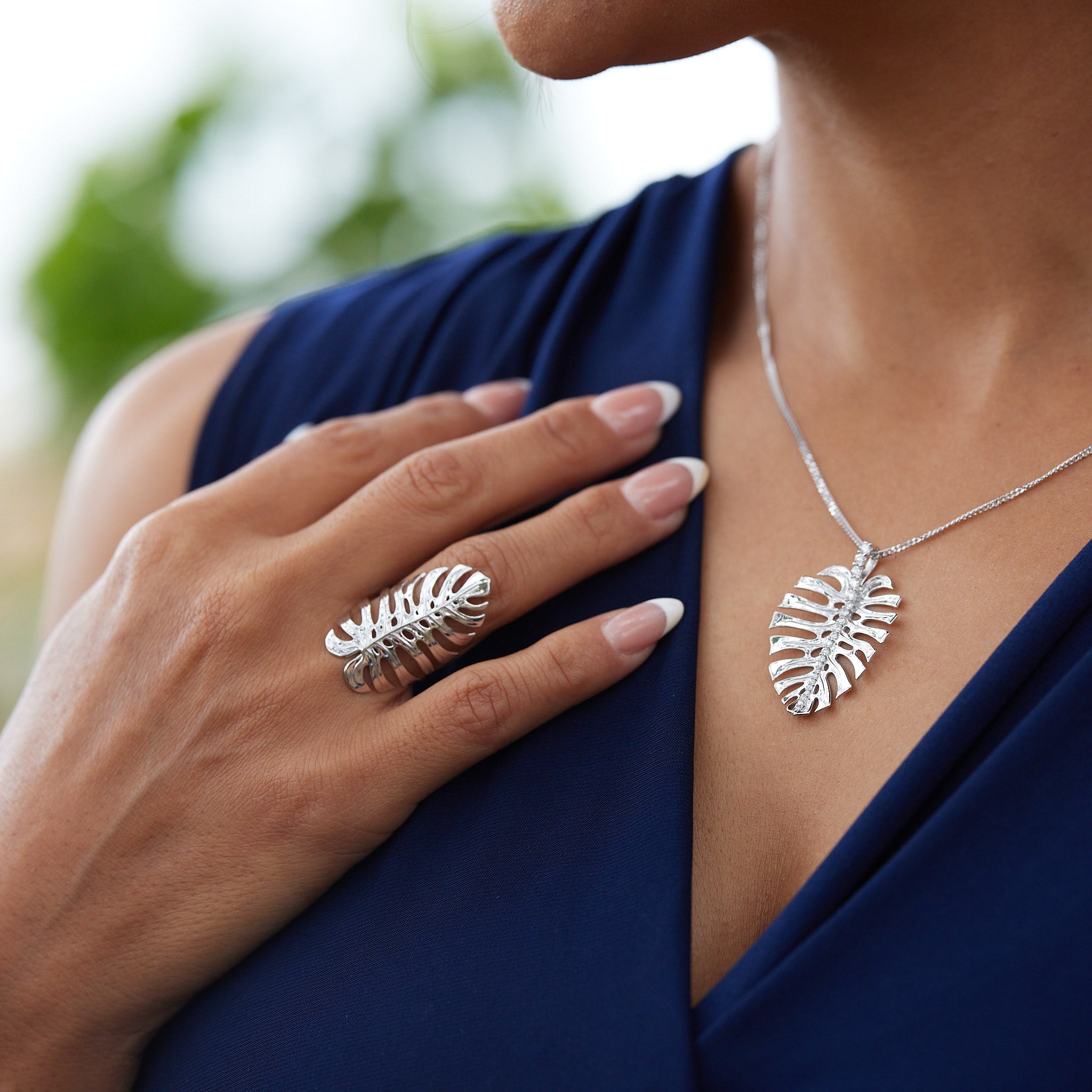 A woman wearing a Monstera Ring and Pendant in White Gold