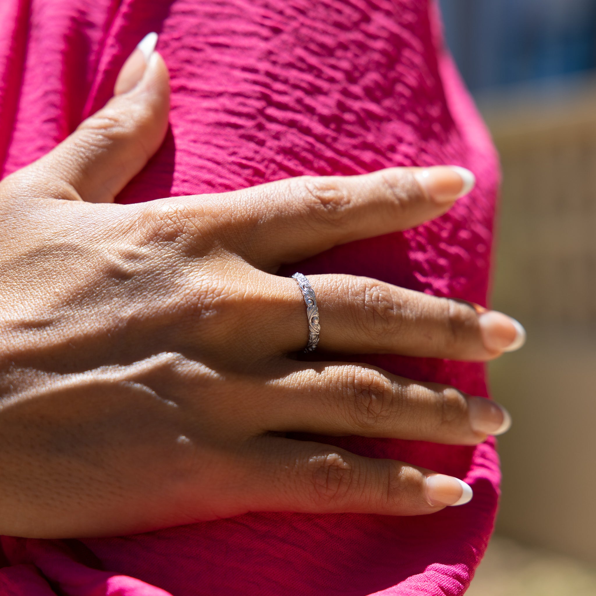 Close up of Living Heirloom Ring in White Gold with Diamonds on a woman's hand resting on her pink top