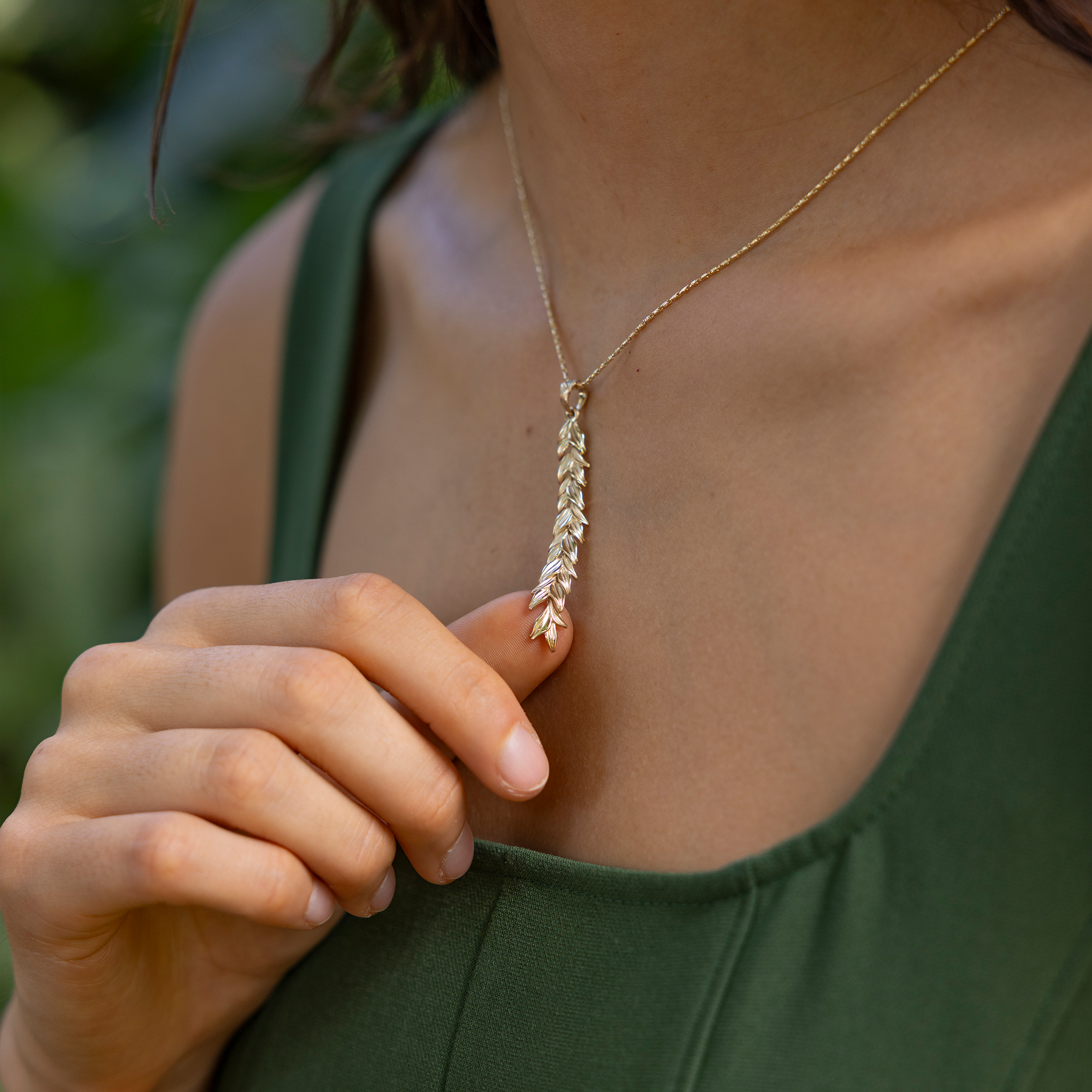 Close up of a woman wearing a 58mm Maile Pendant in Gold