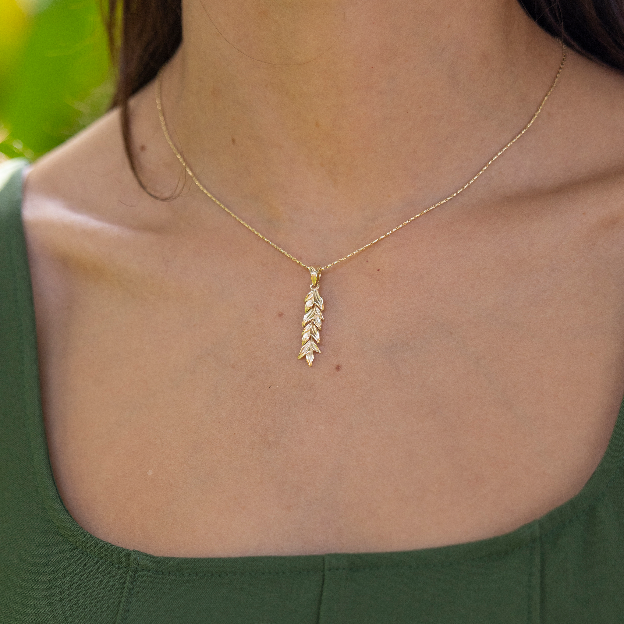 Close up of 35mm Maile Pendant in Gold on a woman's chest