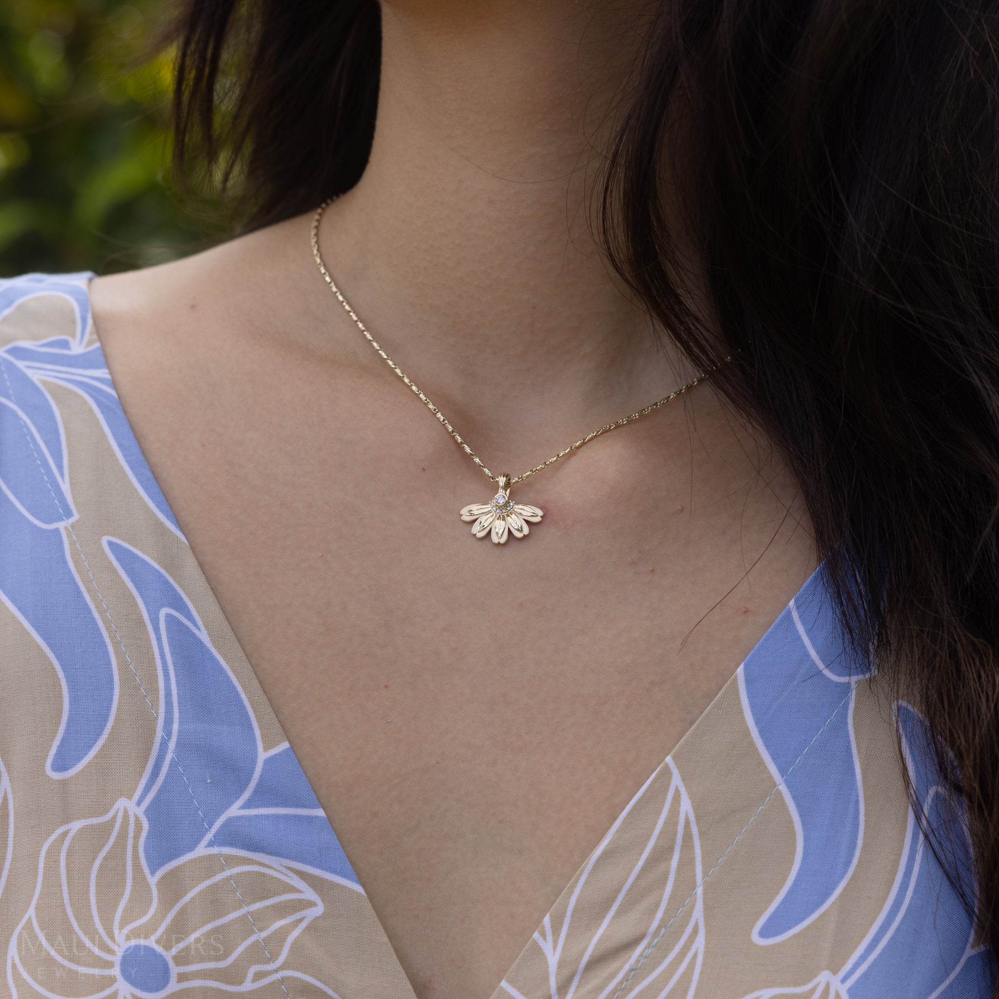 Close up of woman wearing a Beach Naupaka Pendant in Gold with Diamonds