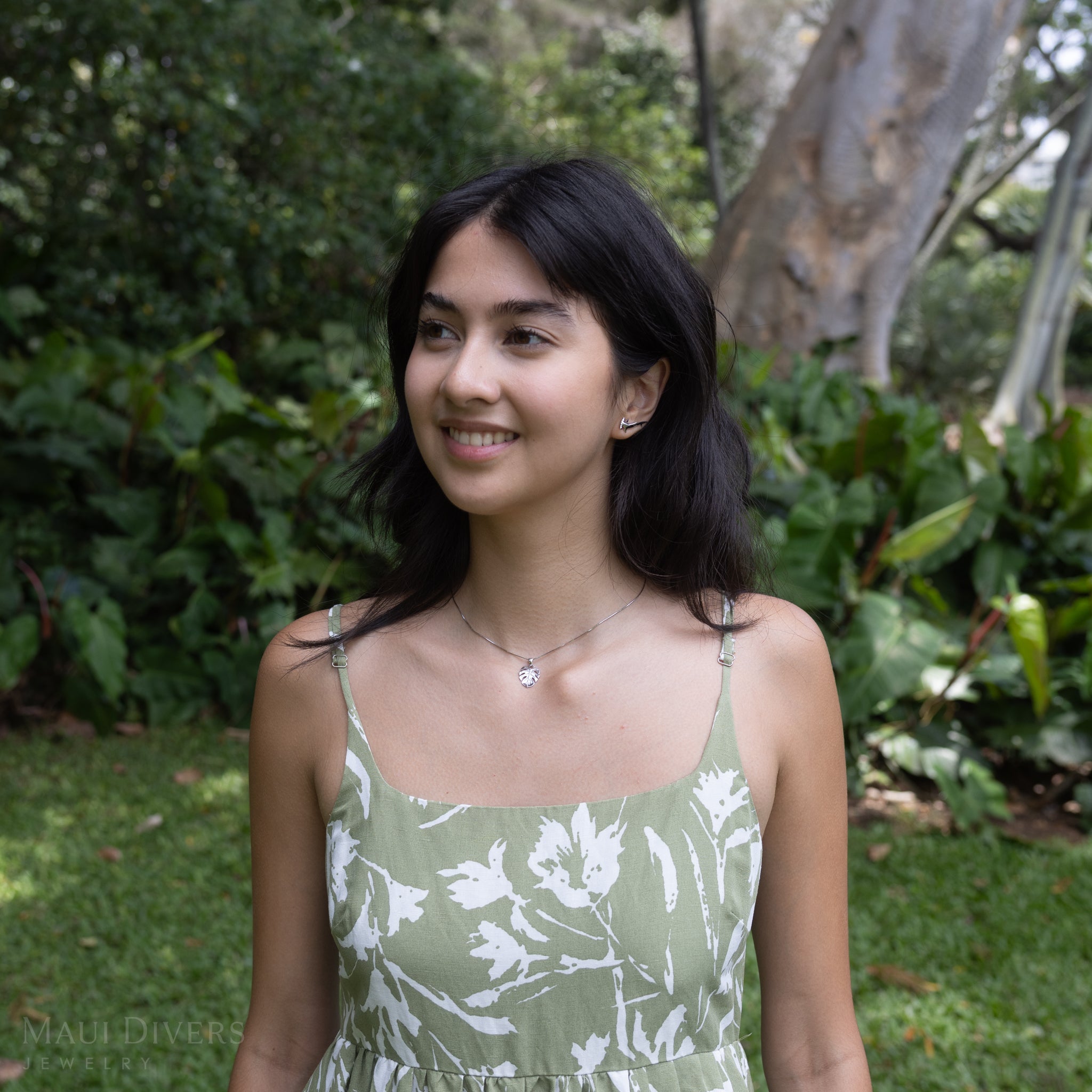 Woman in a garden wearing a Monstera Pendant in Sterling Silver