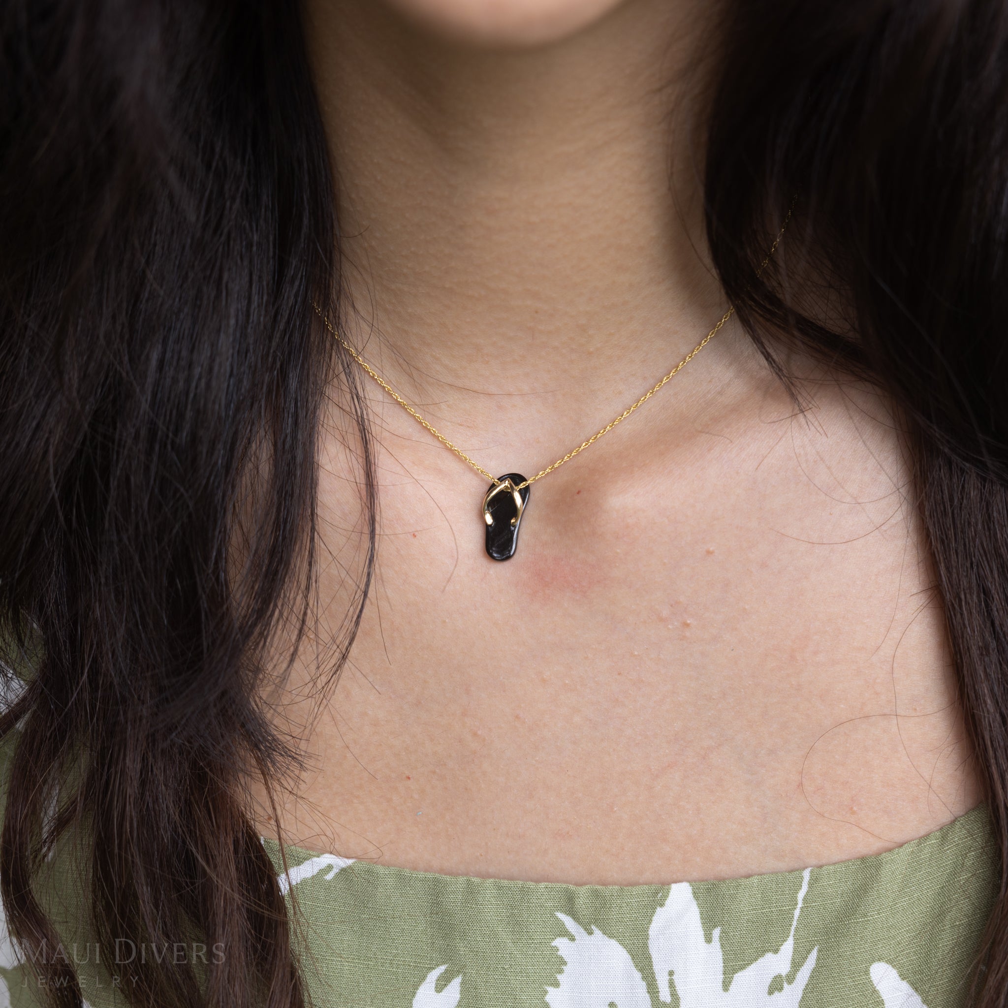 Close up of woman wearing Hawaiian Black Coral Slipper Pendant with 14k Yellow Gold Straps