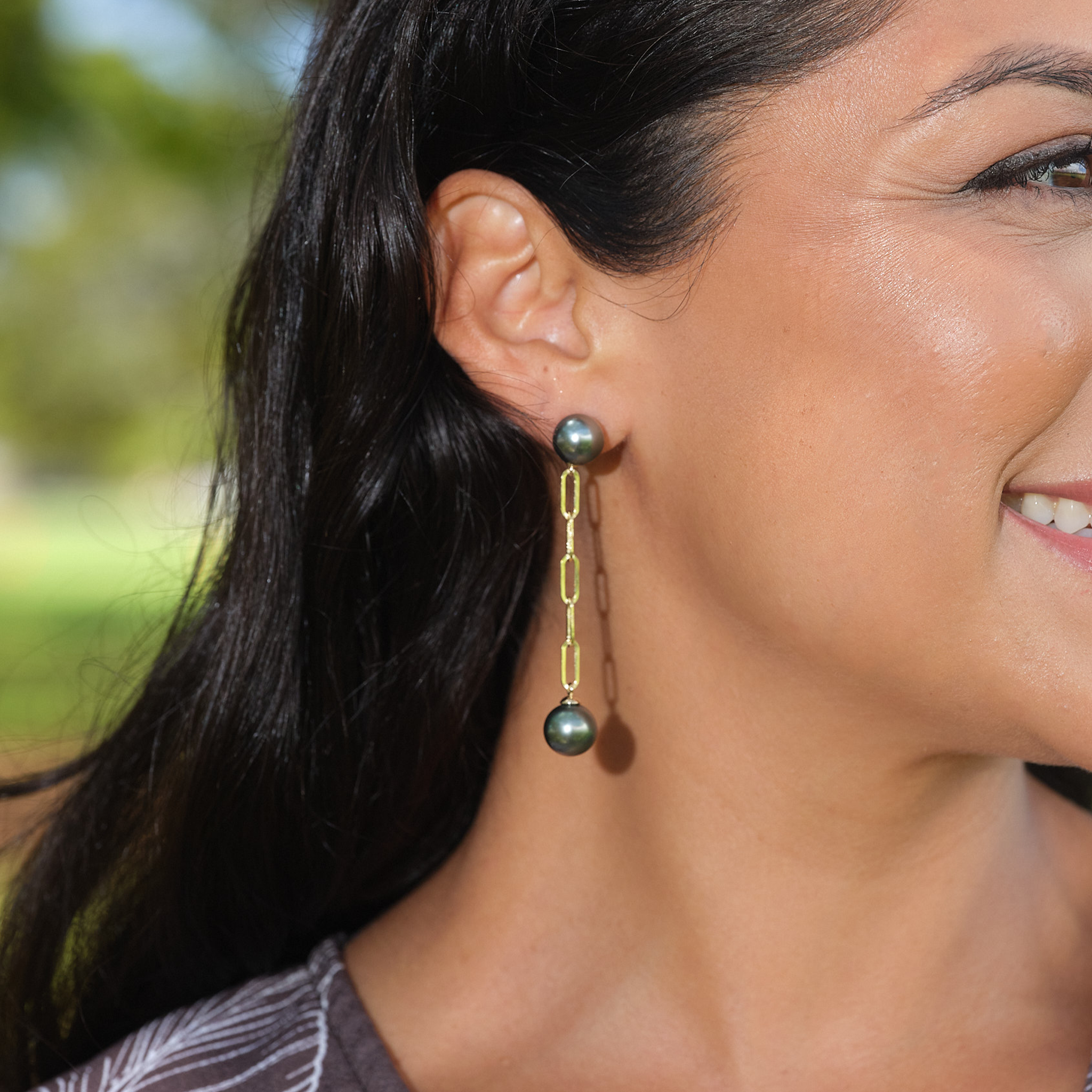 A womanʻs ear with 9-11mm Tahitian Black Pearl Paperclip Chain Earrings in 14k Yellow Gold
