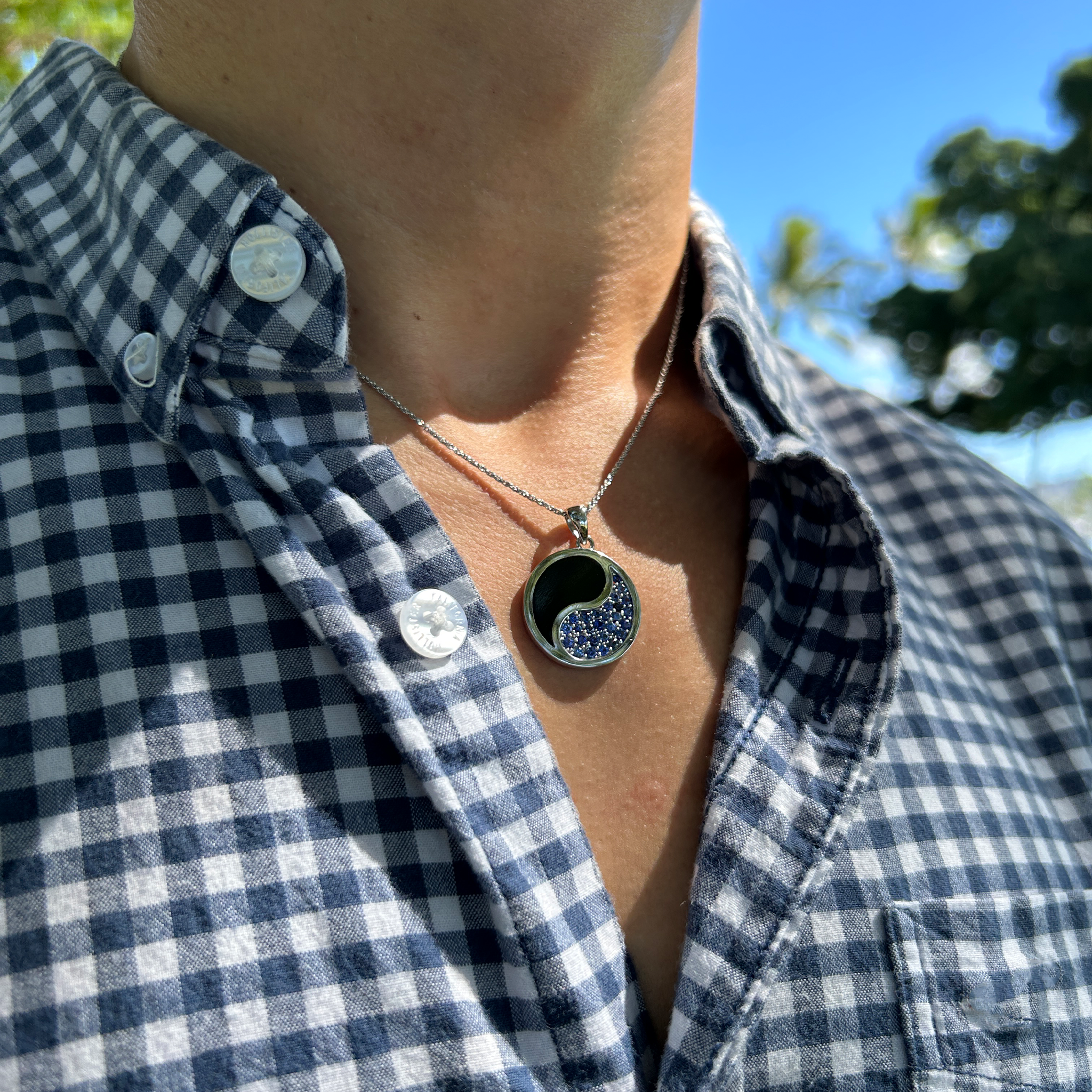 A man wearing a 1.0mm Rope Chain in 14k White Gold with a Yin Yang pendant outdoors