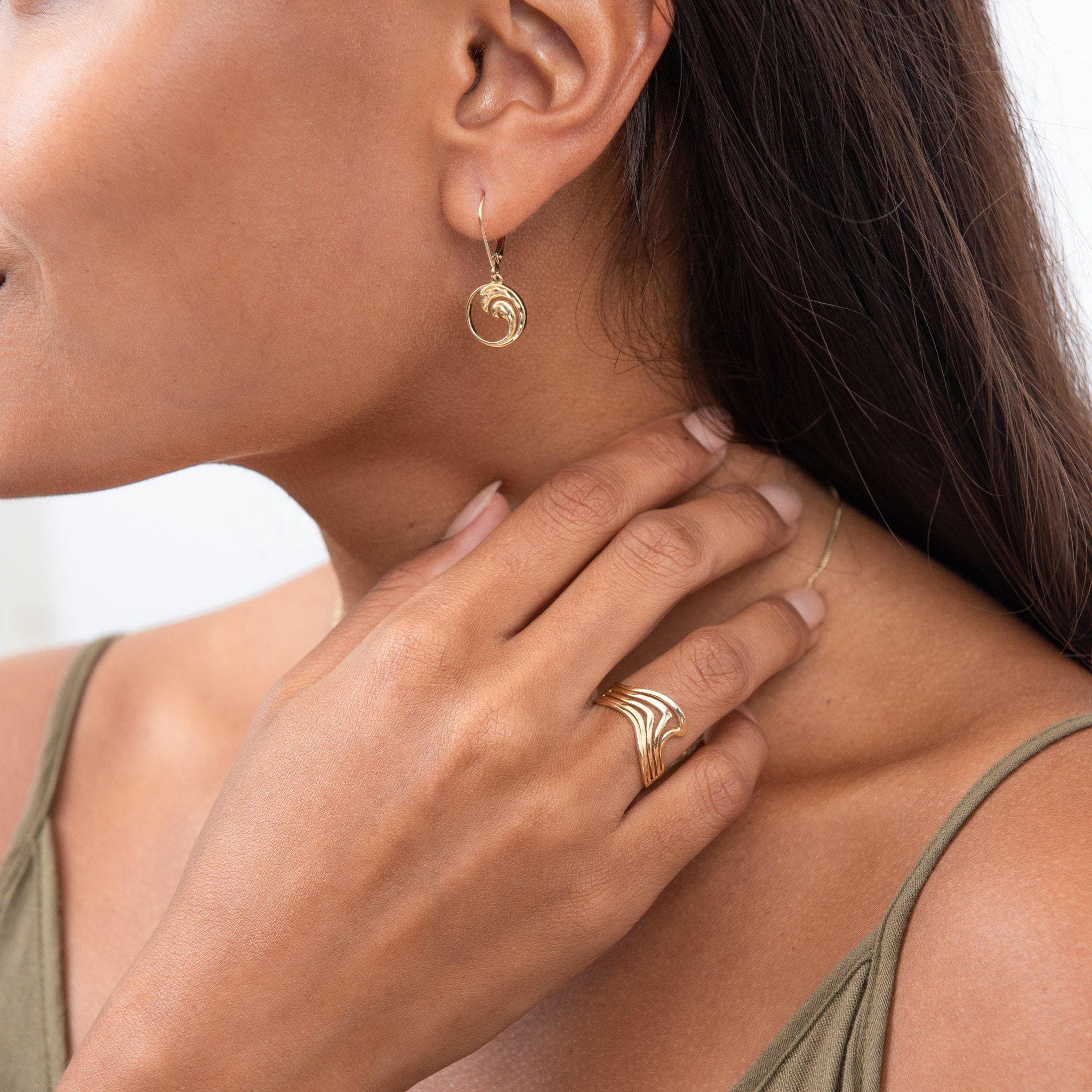 A woman wearing a Nalu Ring in Gold and earrings - Maui Divers Jewelry