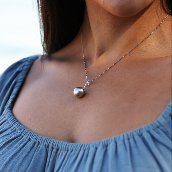 A woman's chest with a Tahitian Black Pearl Pendant in White Gold with Diamonds - 12-14mm - Maui Divers Jewelry