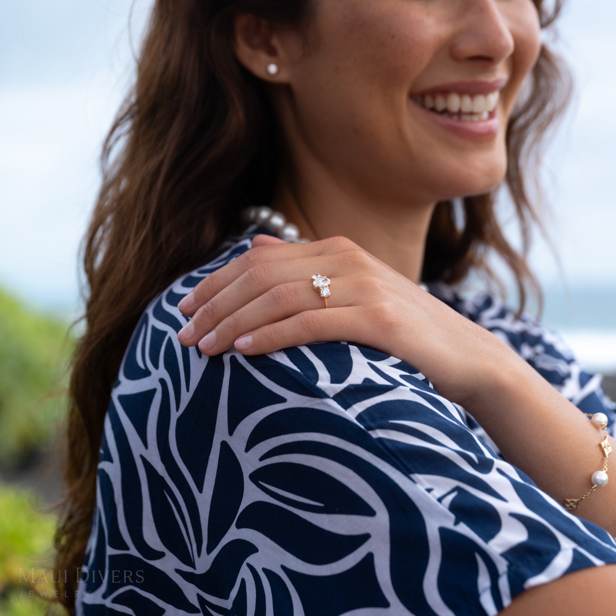 Close-up of a hand wearing a Hidden Hawaiʻi 3-stone lab-grown diamond ring 