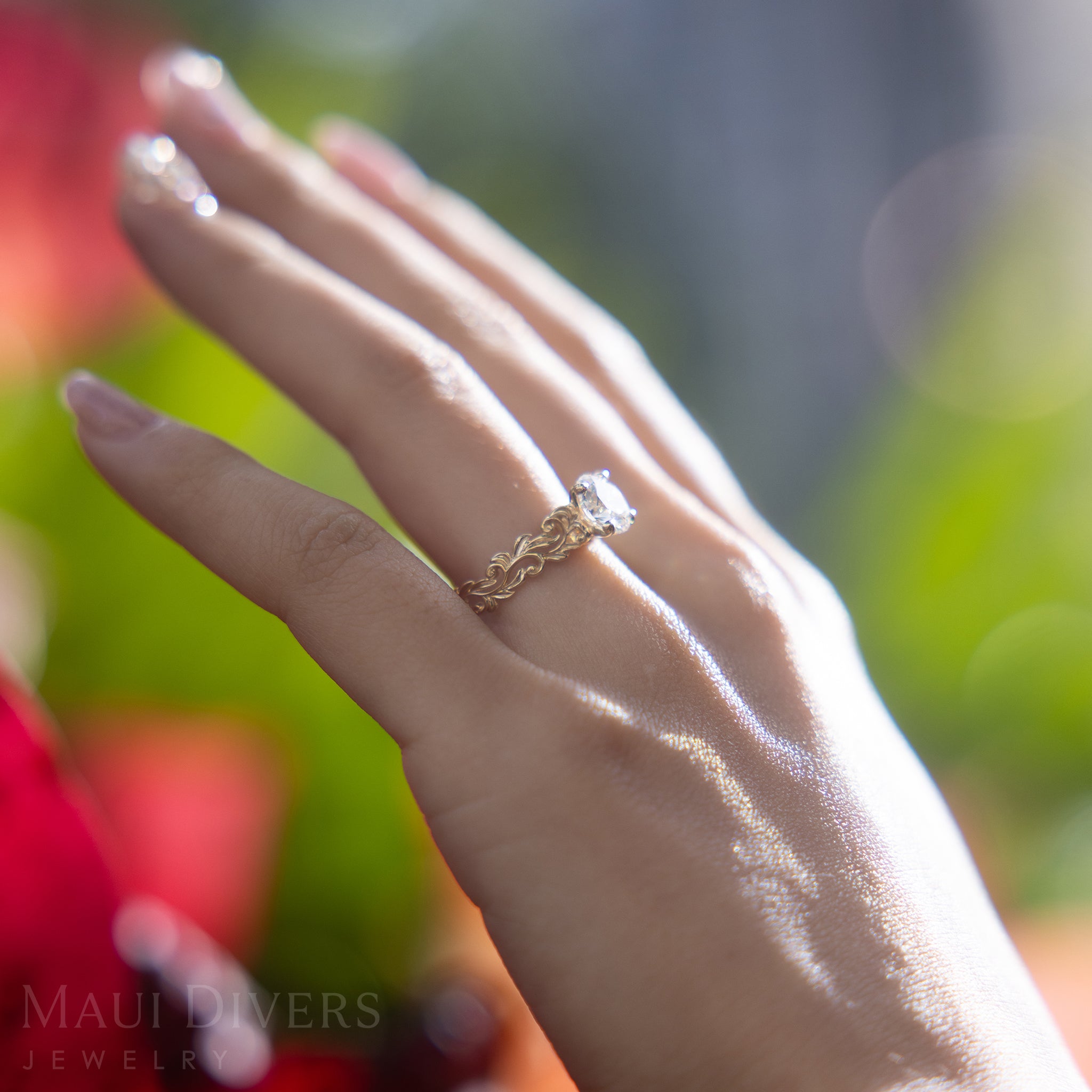 Hand wearing a Living Heirloom Solitaire Lab Grown Diamond Ring in Gold on a blurred natural background