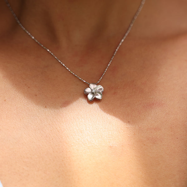 Close up of Plumeria Pendant in White Gold with Diamond - 13mm on neckline