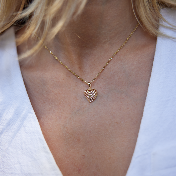 Close up of woman's neckline wearing Aloha Heart Pendant in Gold - 12mm