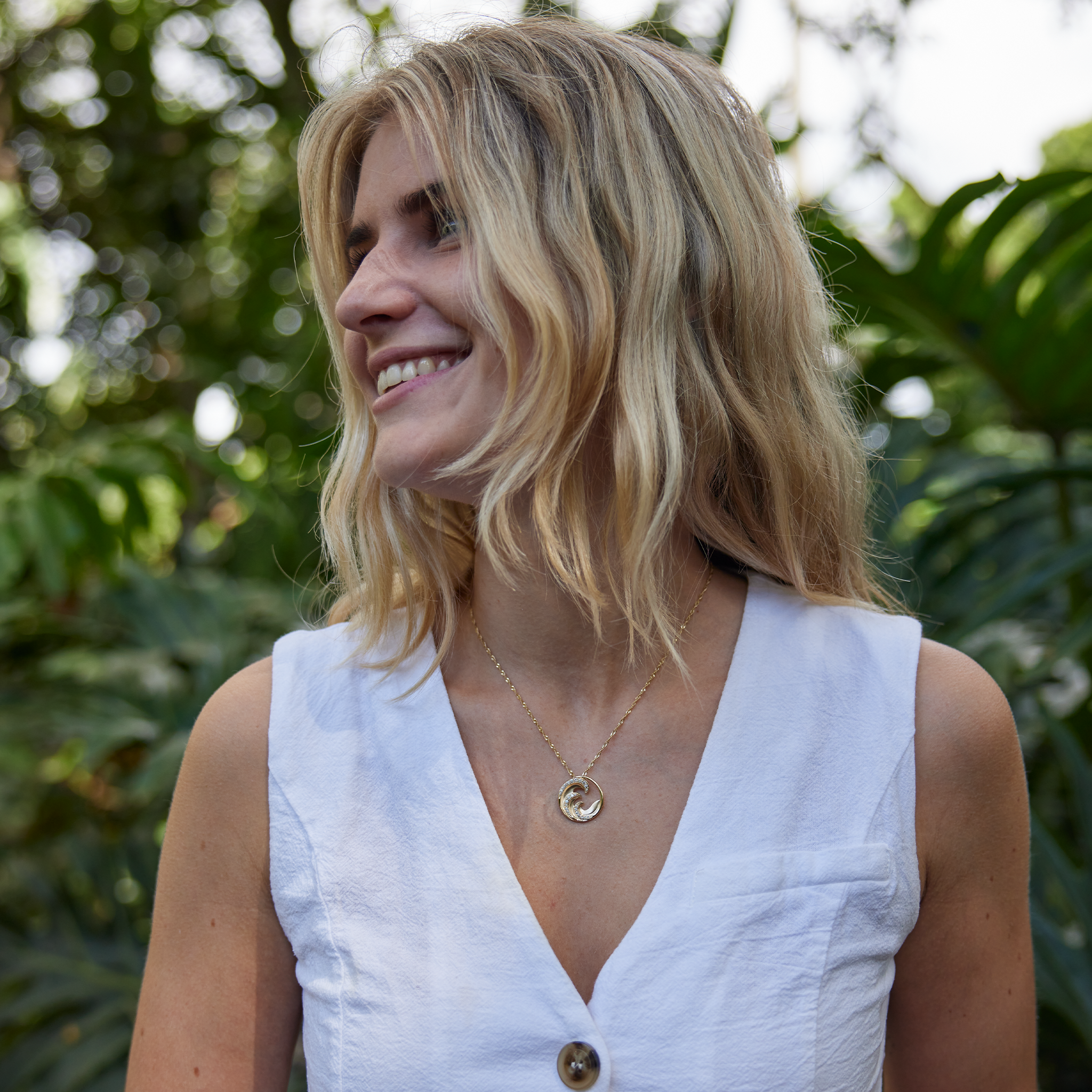 Woman in white shirt wearing Nalu Pendant in Gold with Diamonds - 22mm