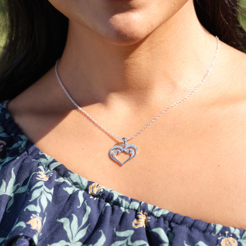 A womanʻs chest with a Nalu Heart Pendant in White Gold with Diamonds - 20mm - Maui Divers Jewelry