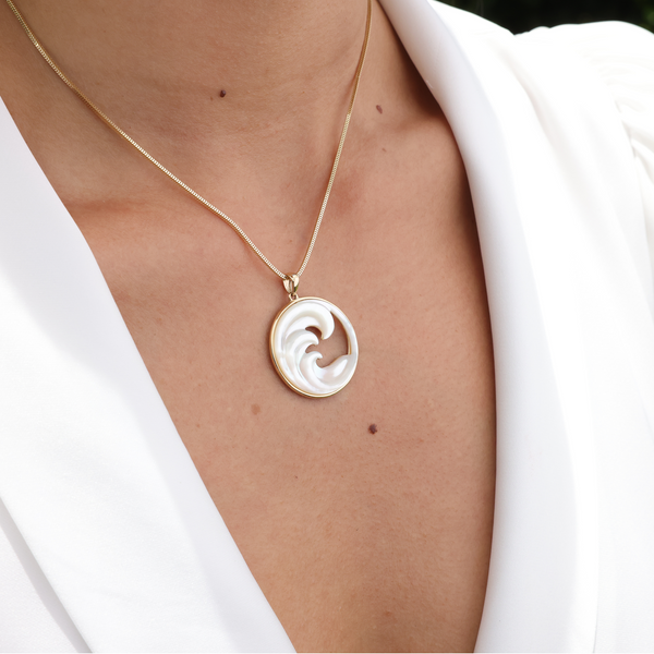 A womanʻs chest with a NAlu Mother of Pearl Pendant in Gold - 27mm - Maui Divers Jewelry