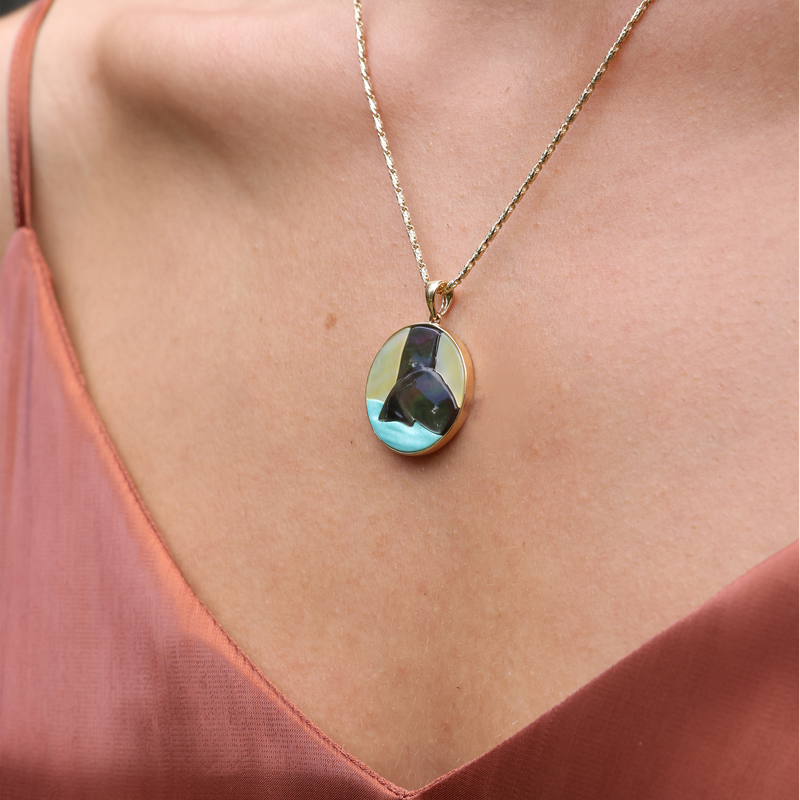 Womanʻs neckline wearing Hawaiian Moments Whale Tail Mother of Pearl & Turquoise Pendant in Gold - 22mm