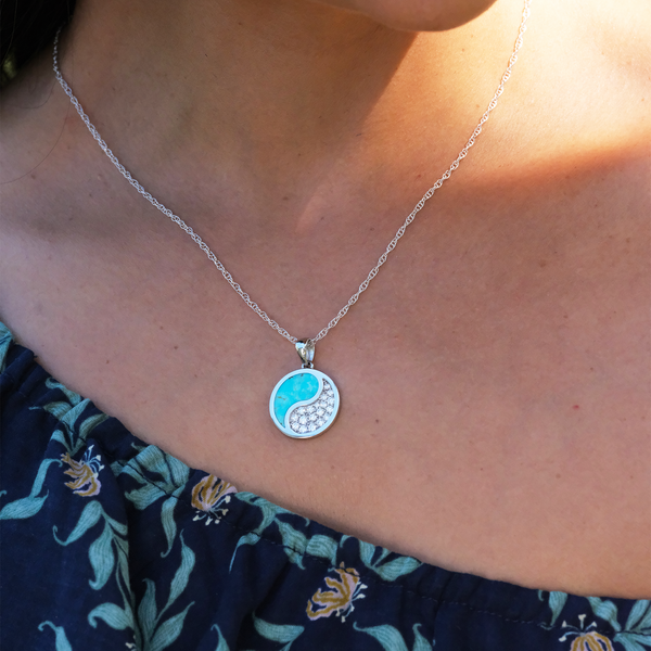 A woman's chest with a Yin Yang Turquoise Pendant in White Gold with Diamonds - 18.5mm - Maui Divers Jewelry