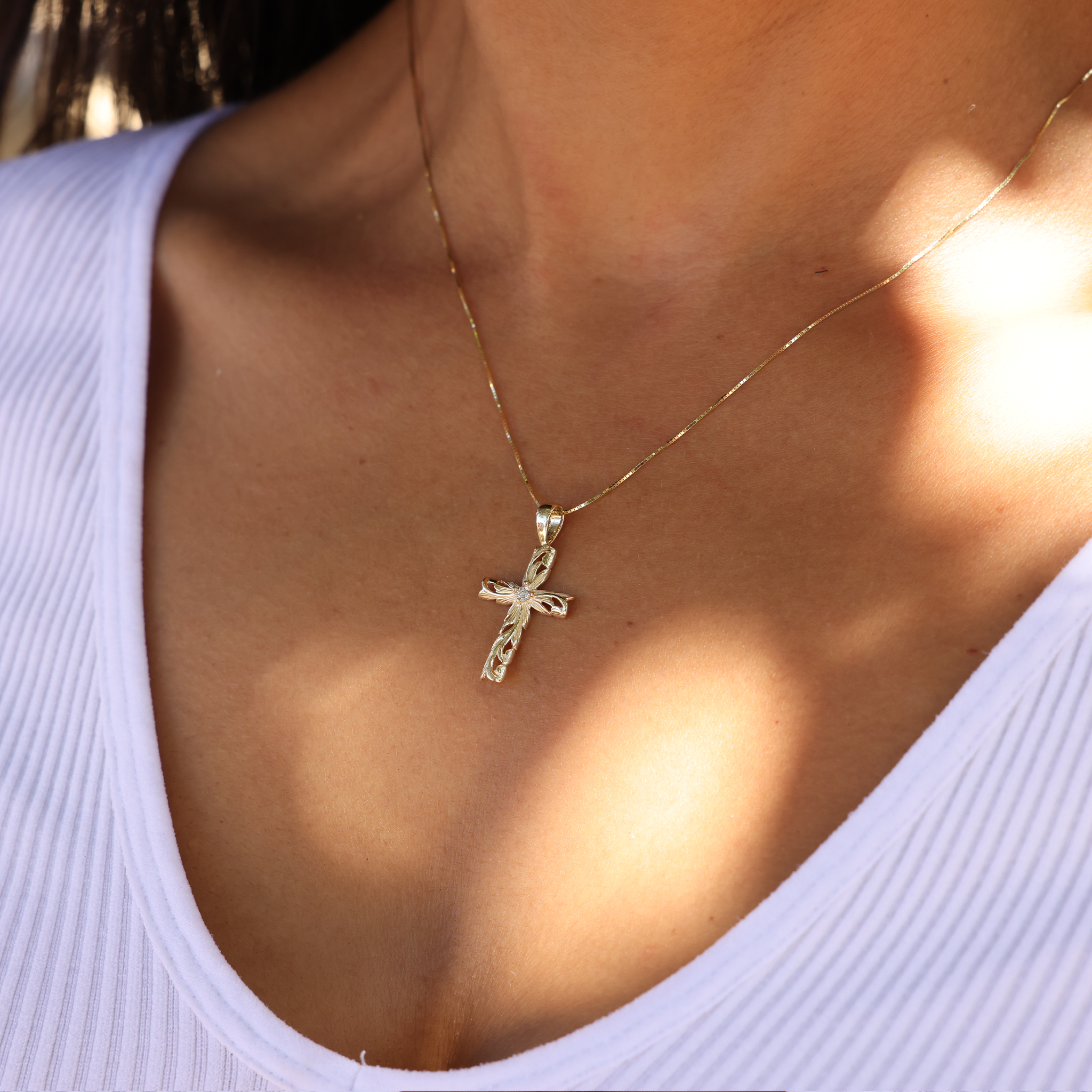 Hawaiian Heirloom Old English Scroll Cross Pendant in Gold with Diamond  on Chest just below the necklace with a white shirt