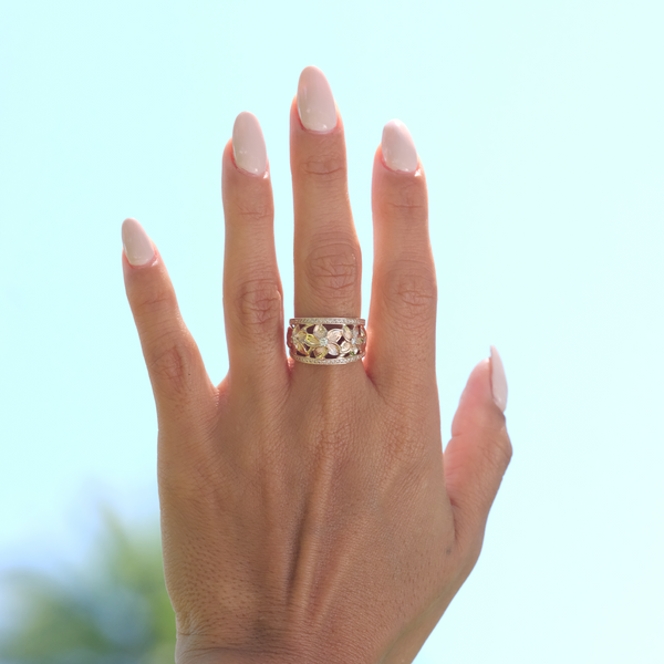 A womanʻs hand wearing a Hawaiian Heirloom Plumeria Ring in Rose Gold with Diamonds -13mm - Maui Divers Jewelry