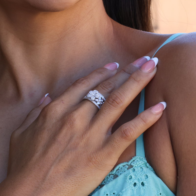 Hawaiian Heirloom Plumeria Ring in White Gold with Diamonds  on Hand touching shoulder over teal shirt
