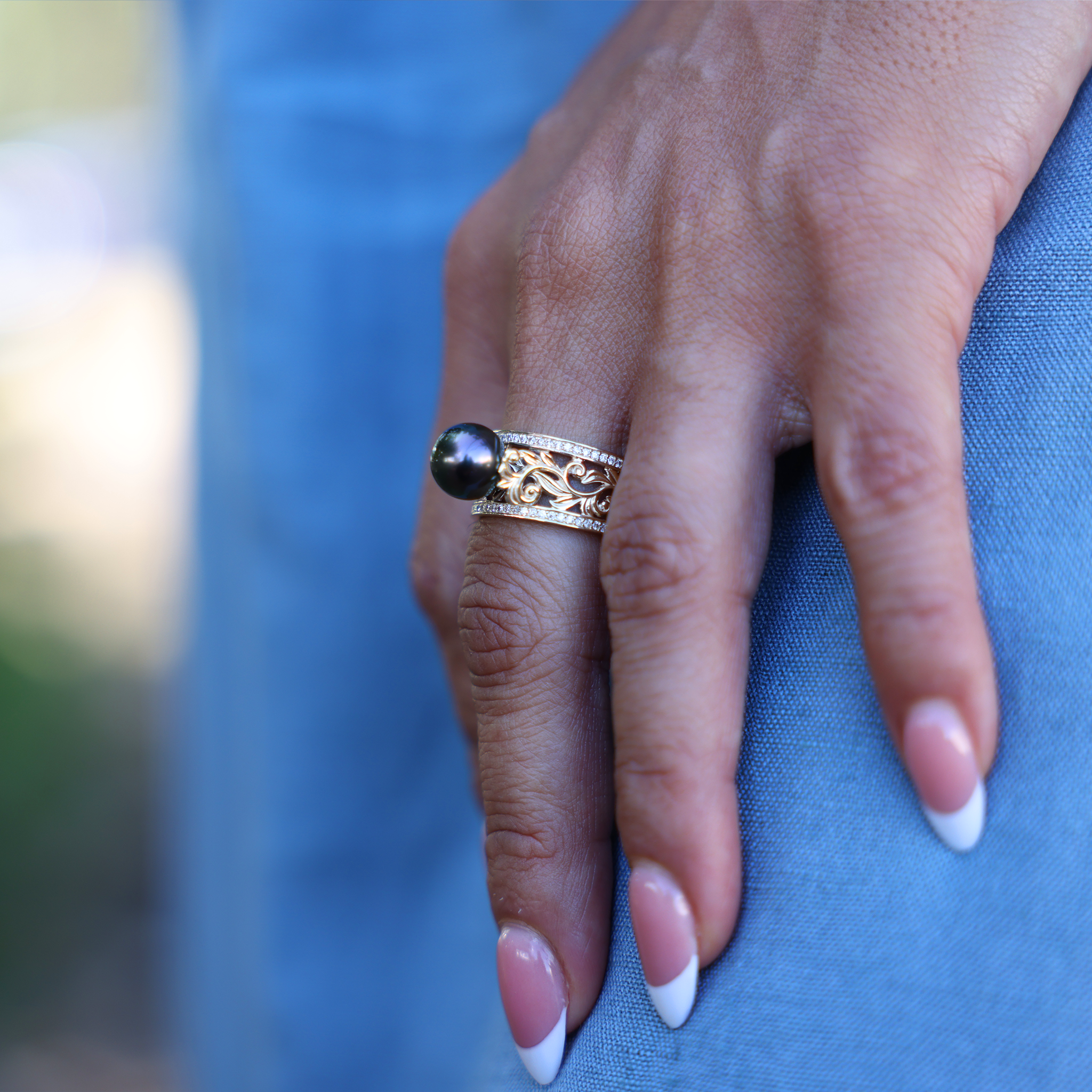 Hawaiian Heirloom Tahitian Black Pearl Ring in Gold with Diamonds on Hand over blue dress - Maui Divers Jewelry