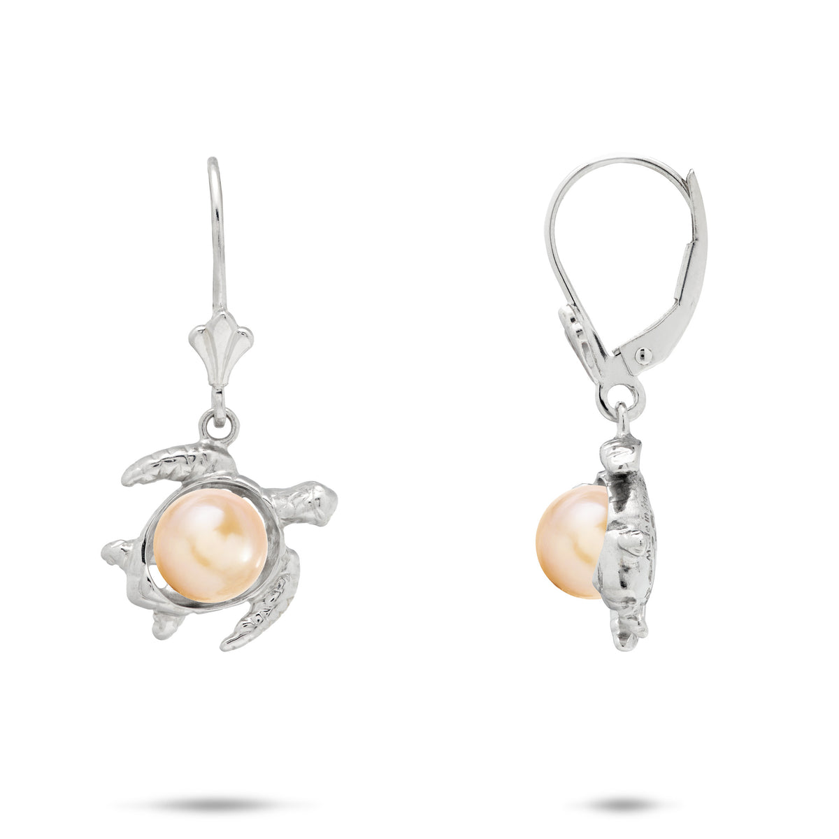 A pair of sterling silver earrings featuring a Hawaiian green sea turtle-shaped setting holding a round, peach freshwater pearl, shown against a plain white background.