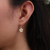 A womanʻs ear with Plumeria Earrings in Gold with Diamonds - 11mm - Maui Divers Jewelry