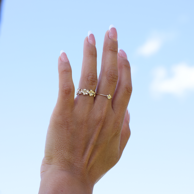 Plumeria Eternity Ring in Gold with Diamonds on Hand with Blue sky background