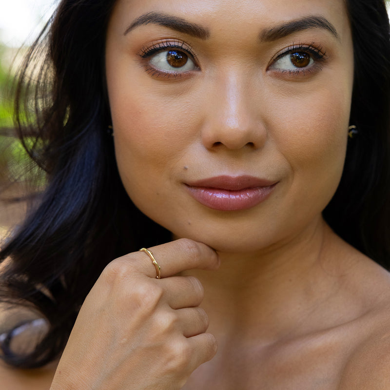 Woman looking up and showcasing the Heritage Ring in Gold