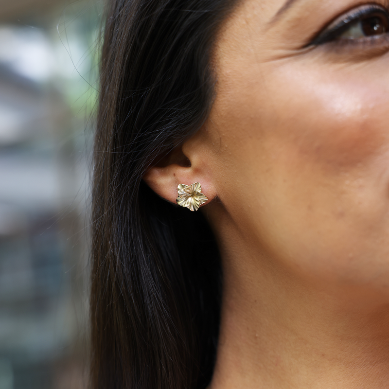 A womanʻs ear with Hawaiian Gardens Hibiscus Earrings in Gold with Diamonds - 14mm -Maui Divers Jewelry