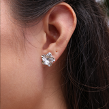 A woman's ear with Hawaiian Gardens Hibiscus Earrings in White Gold with Diamonds - 14mm - Maui Divers Jewelry