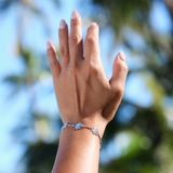 A womanʻs wrist with a Paradise Palms - Palm Tree Bracelet in White Gold with Diamonds - Maui Divers Jewelry
