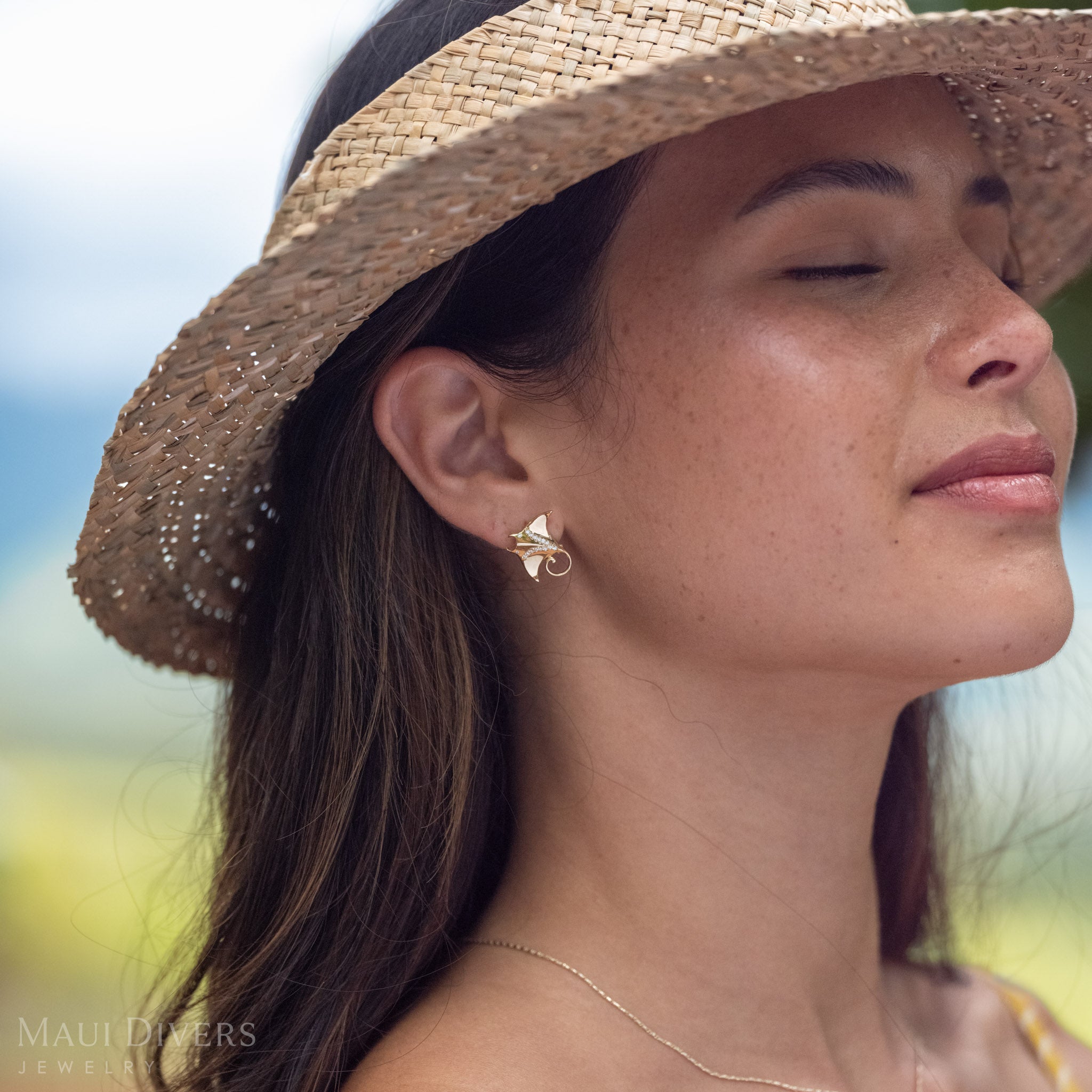 Side-profile showing a close-up of a 14k Gold Manta Ray Earring with Natural Diamond detailing.