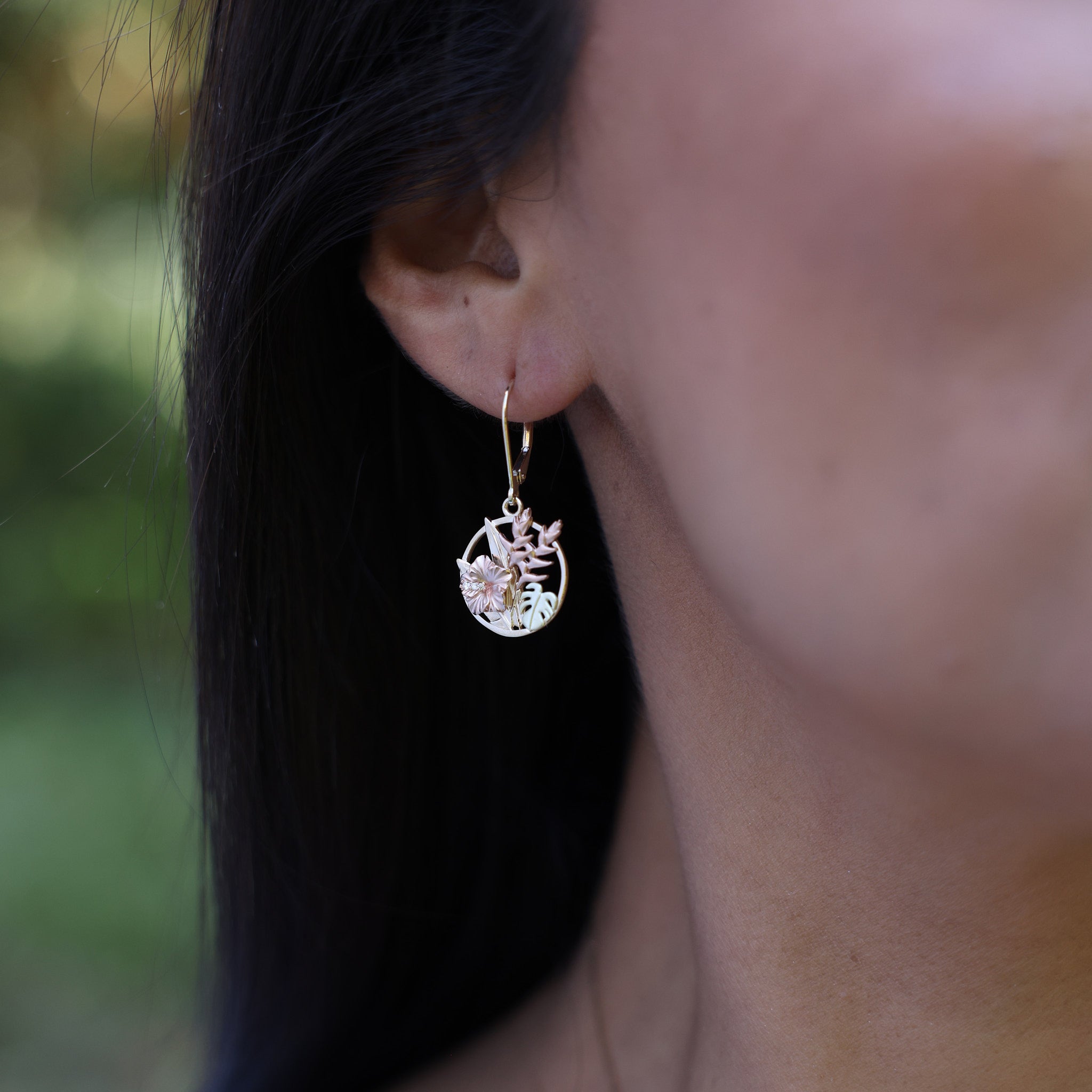 close up of Hawaiian Gardens Hibiscus Earrings in Tri Color Gold with Diamonds - 15mm on woman's ear