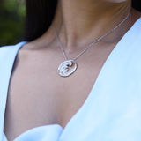 Close up of woman with blue dress wearing Nalu Pendant in White Gold with Diamonds - 26mm