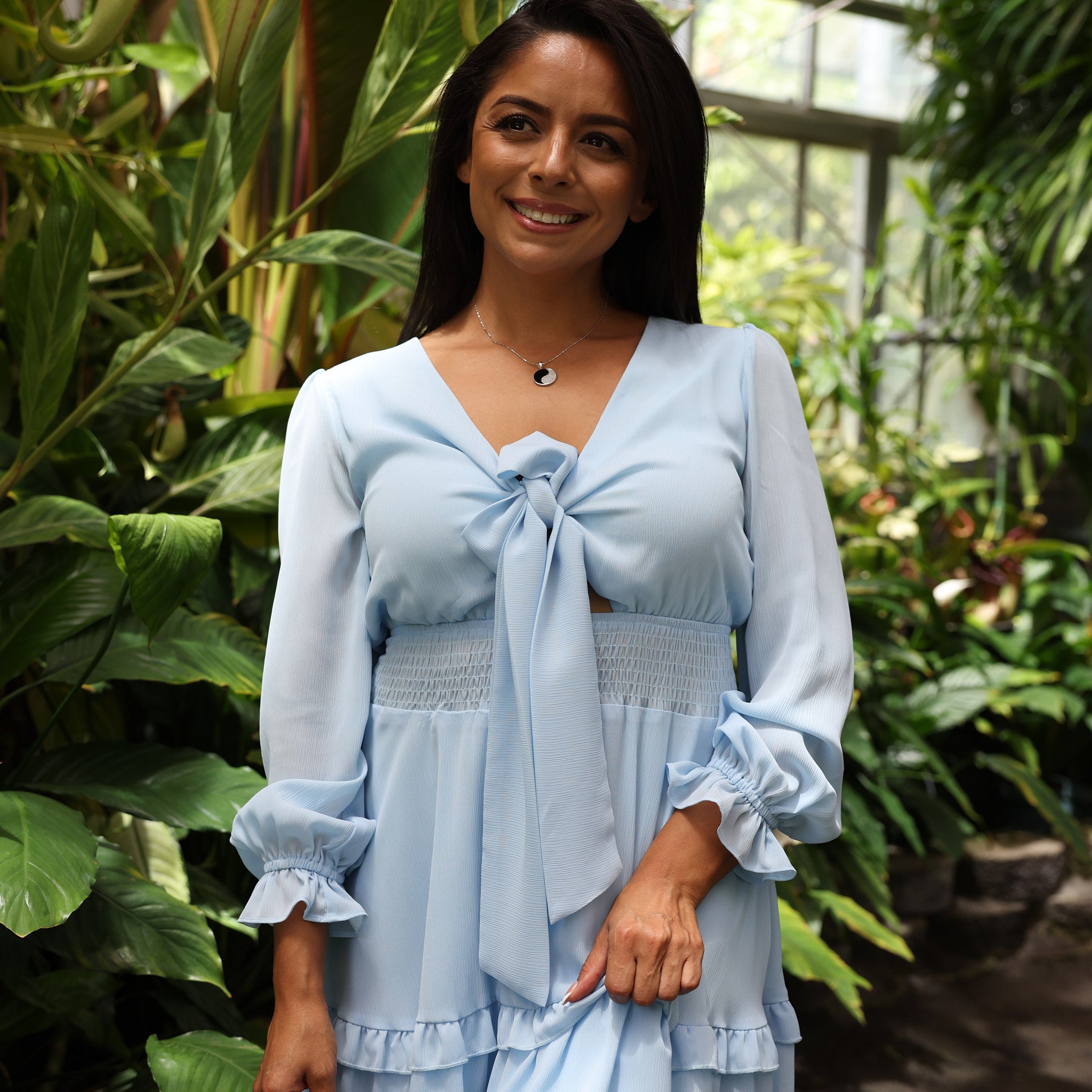 woman in blue dress wearing Yin Yang Black Coral Pendant in White Gold with Diamonds - 19mm walking through botanical garden in Hawaii